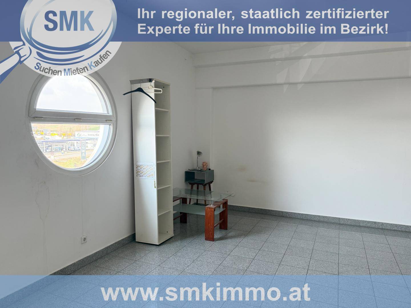 Geräumiger Raum mit runden Fenstern, Fliesenboden und minimalistischer Einrichtung, ideal für Wohnzwecke.