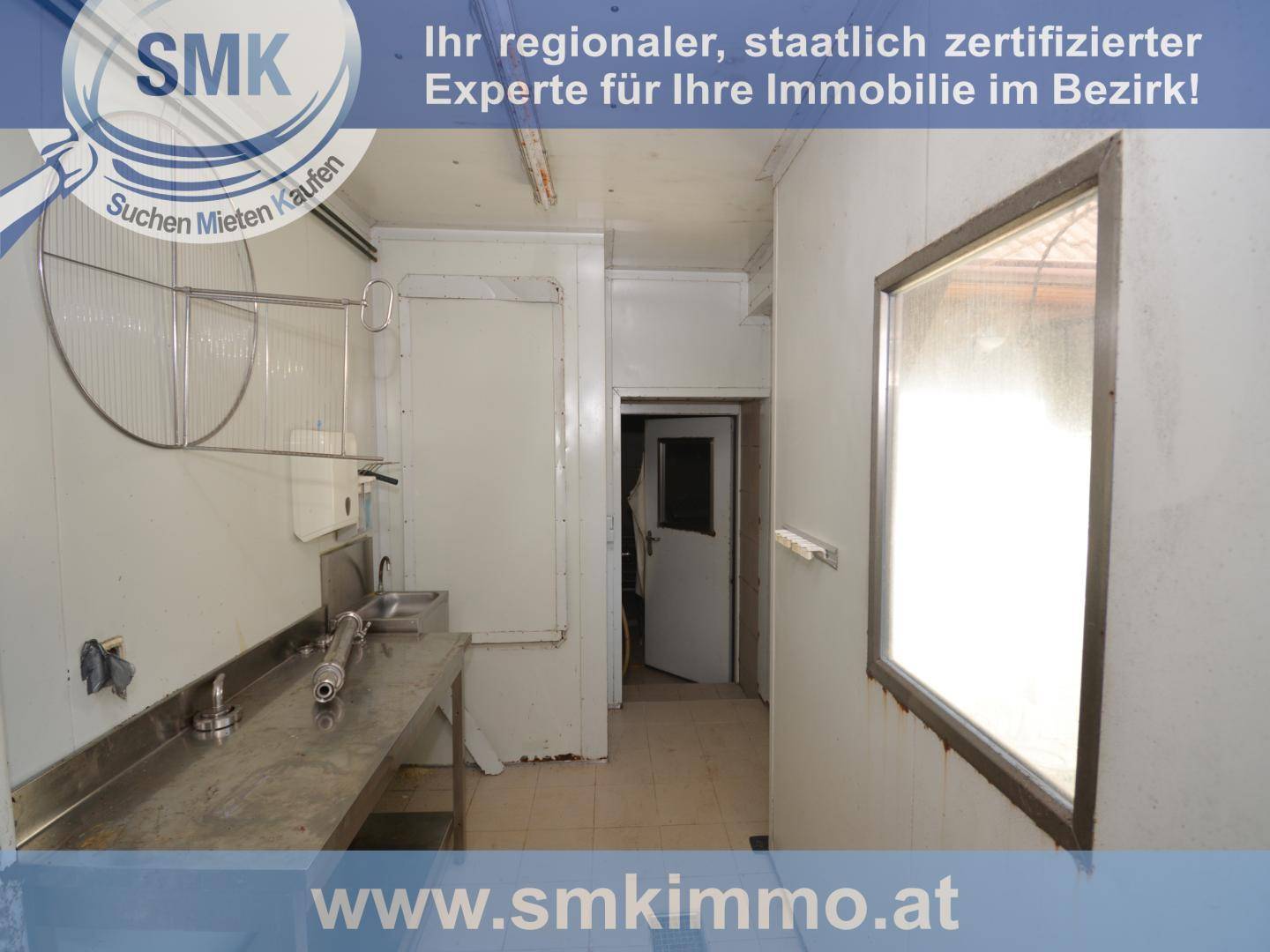 Funktionaler Wirtschaftsraum mit Edelstahlarbeitsflächen, Fliesenboden und einem Fenster.