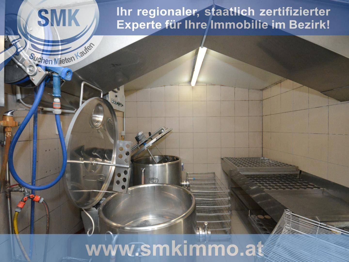 Industrieller Wirtschaftsraum mit großen Metallbehältern und Regalen, geeignet für gewerbliche Nutzung.
