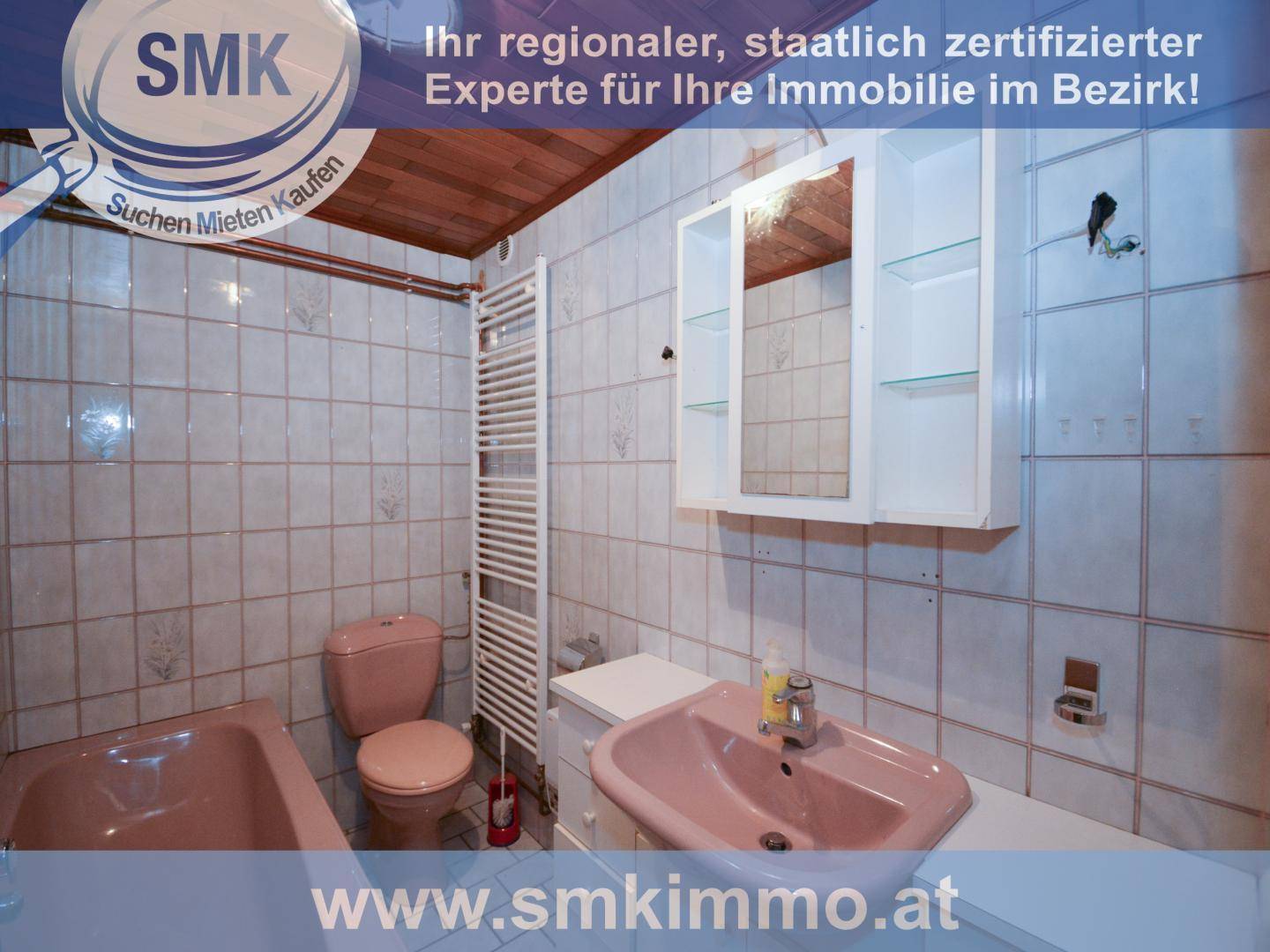 Badezimmer mit rosa Sanitärobjekten, weißen Fliesen und einem beheizten Handtuchhalter.