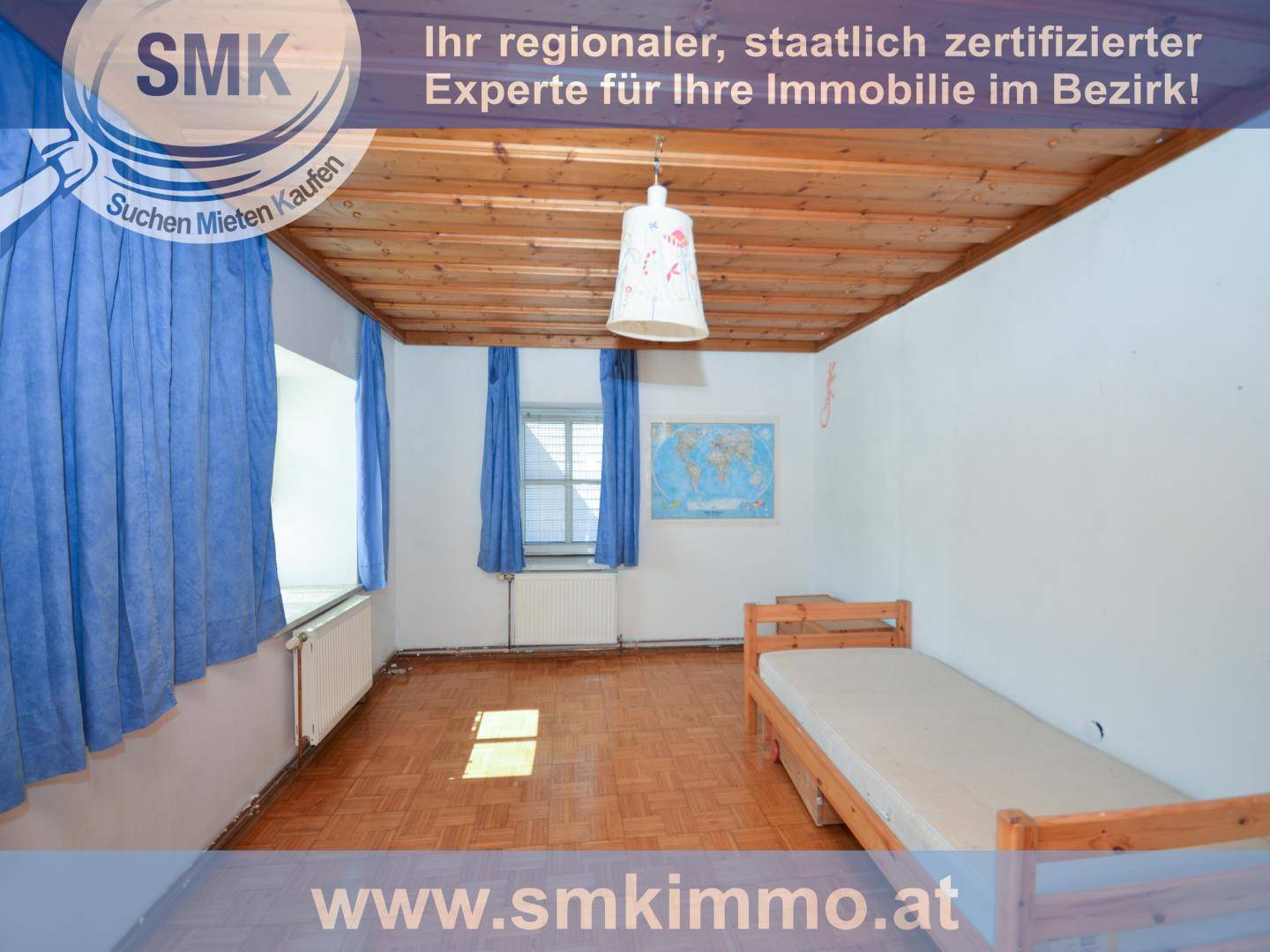 Schlafzimmer mit Holzbalkendecke, Parkettboden und einem Einzelbett am Fenster.