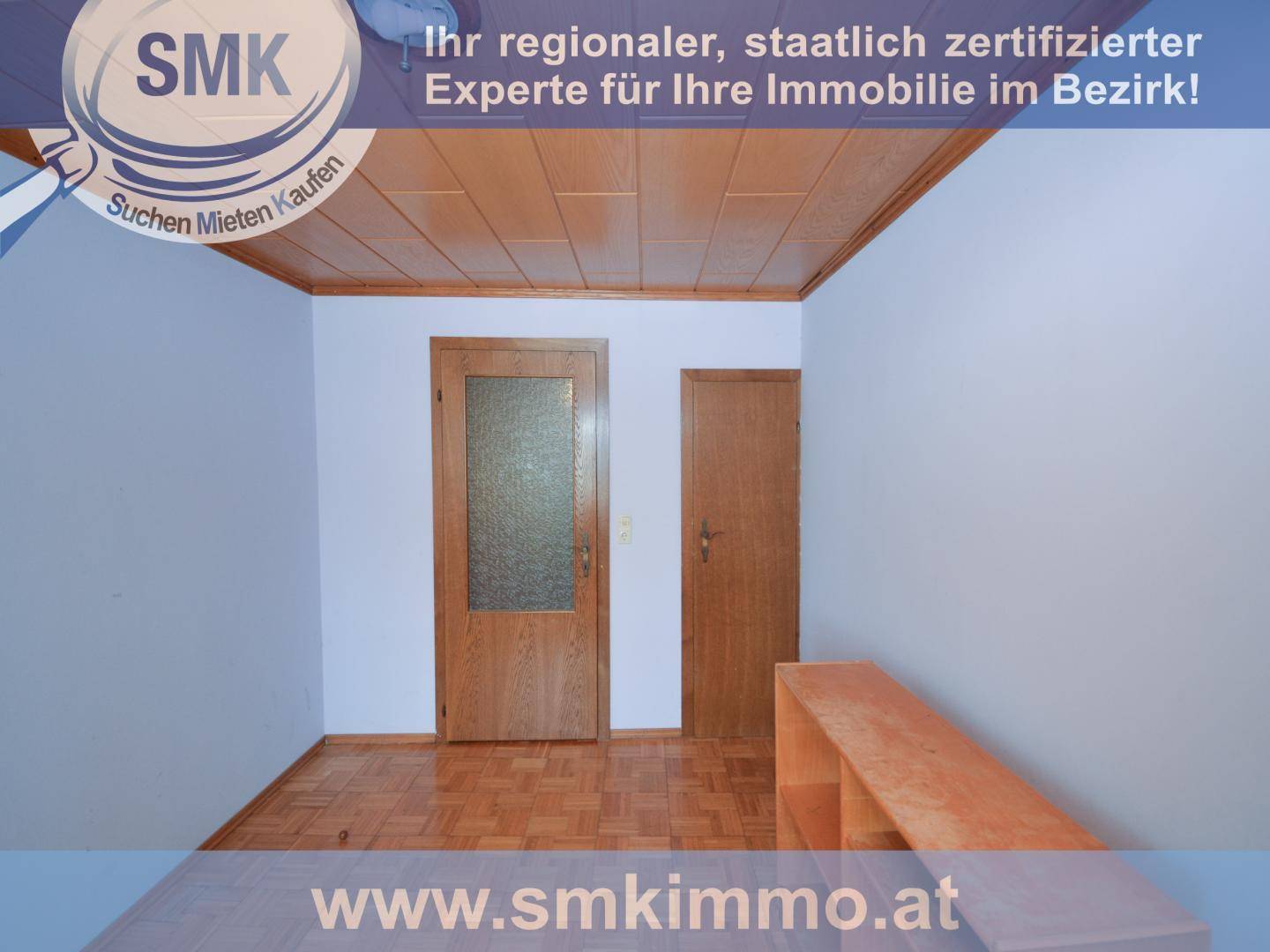 Flur oder kleiner Raum mit Holzdeckenverkleidung und Parkettboden, zwei Türen führen ab.