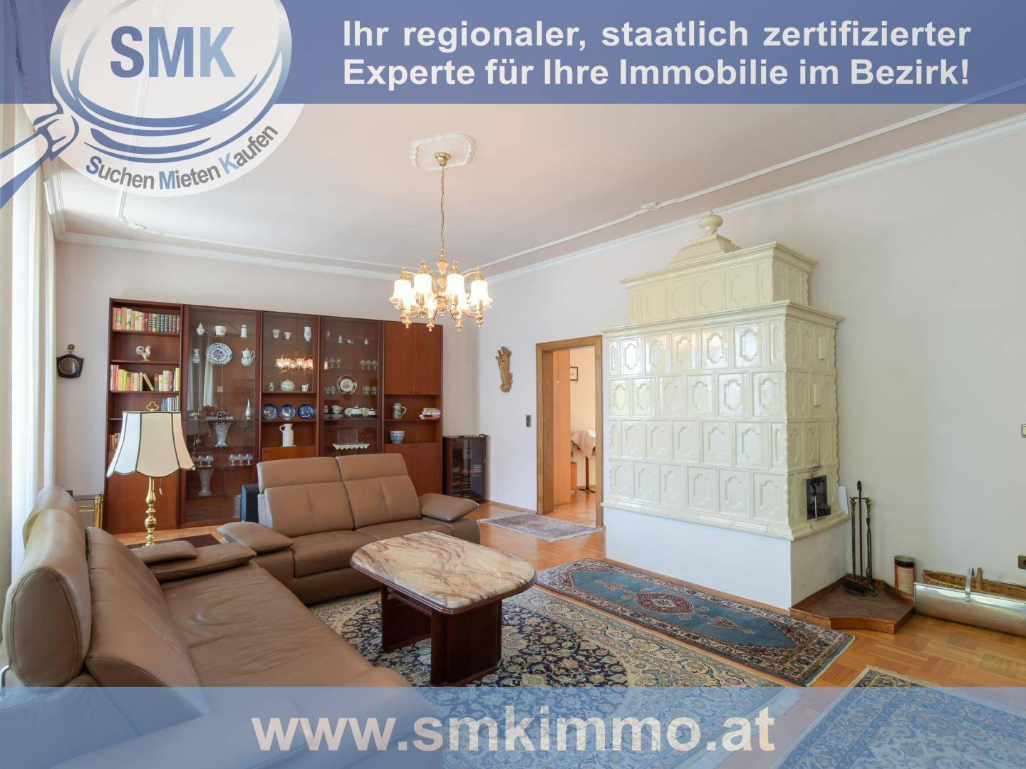 Gemütliches Wohnzimmer mit traditionellem Kachelofen, bequemen Sofas und Kronleuchter.