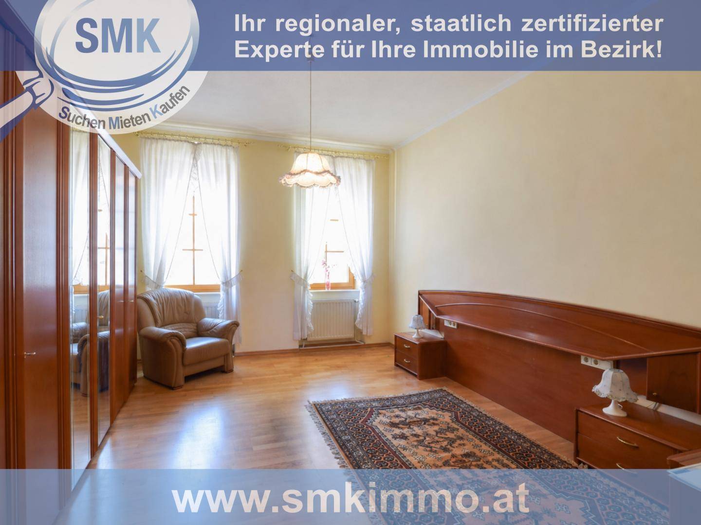 Geräumiges Schlafzimmer mit großem Holzbett, Spiegelschrank und Parkettboden.