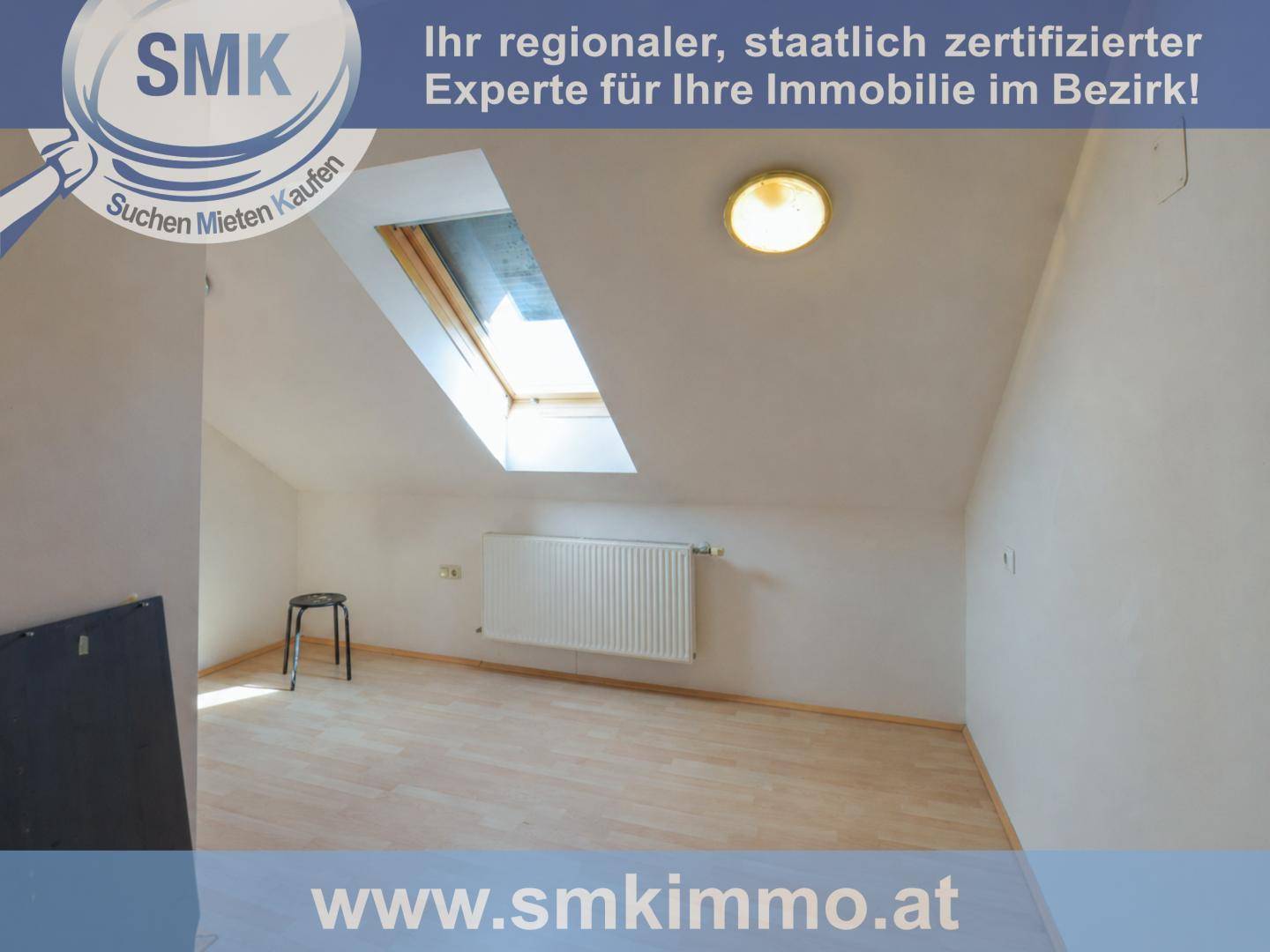 Leeres Dachzimmer mit Dachfenster und Holzboden, bereit für individuelle Gestaltung.