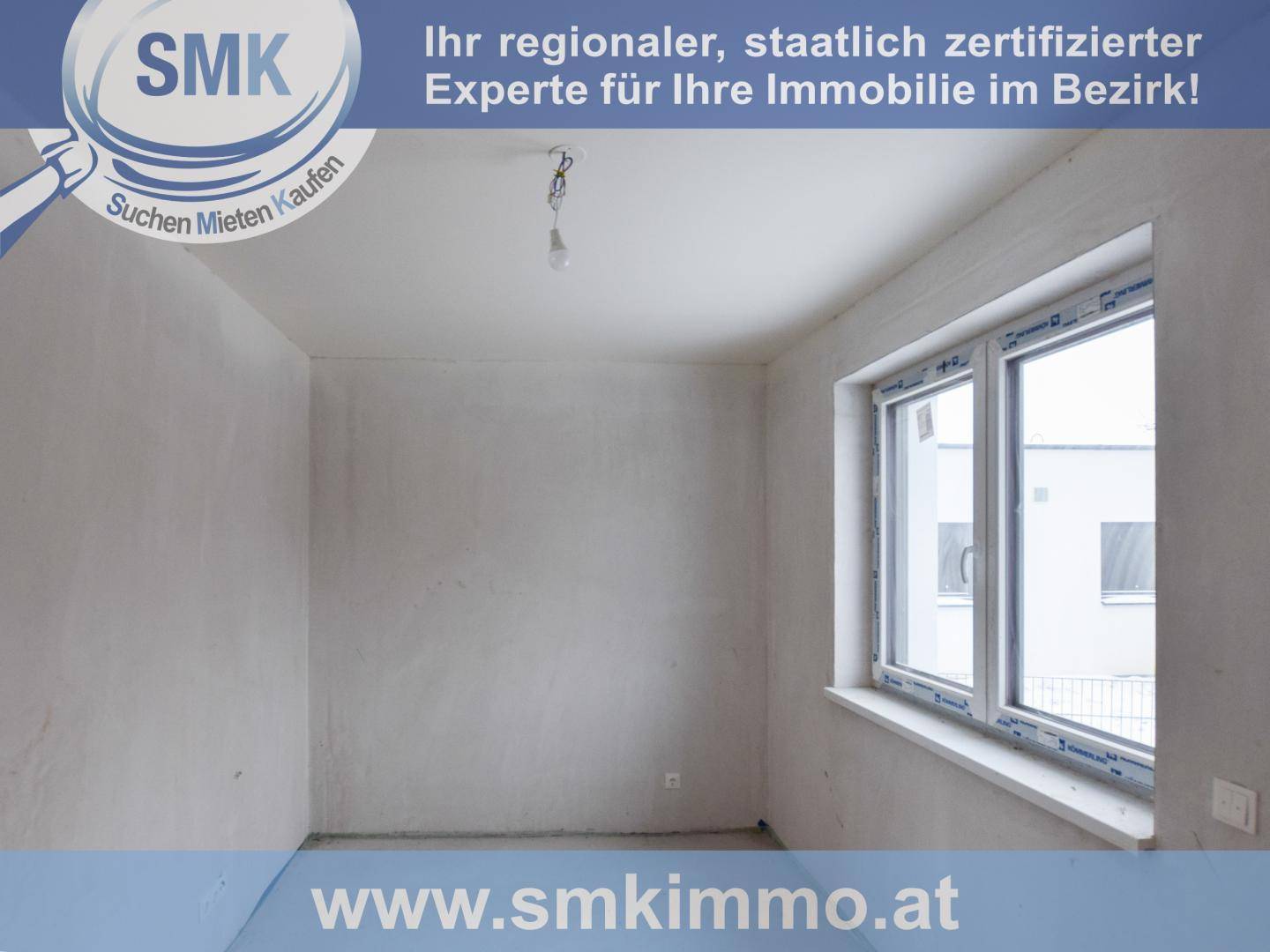 Leerer Raum im Rohbauzustand mit großem Fenster und unfertigen Oberflächen.