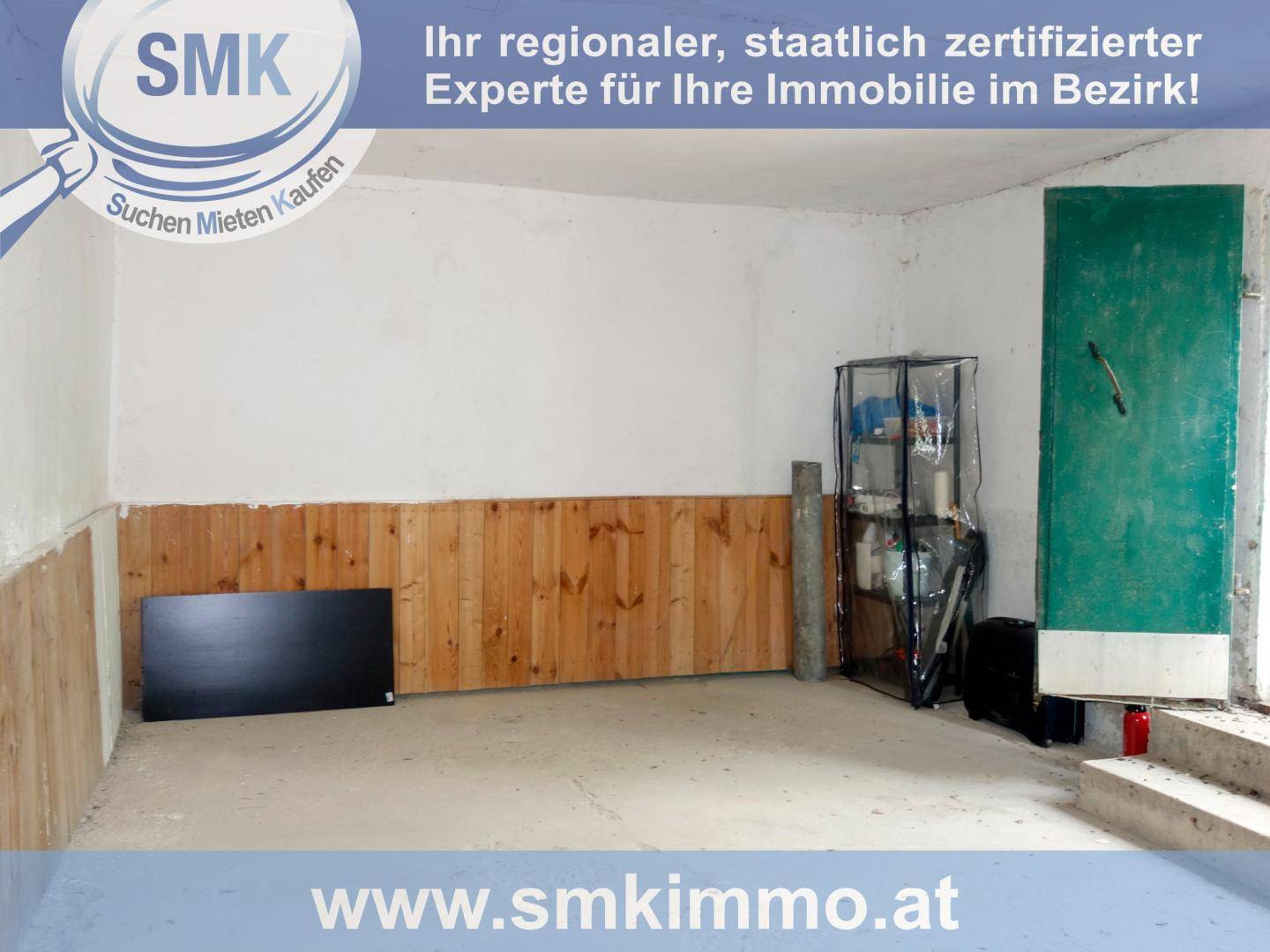 Geräumiger Innenraum mit Betonboden und Holzwänden, ideal als Garage oder Lagerfläche.