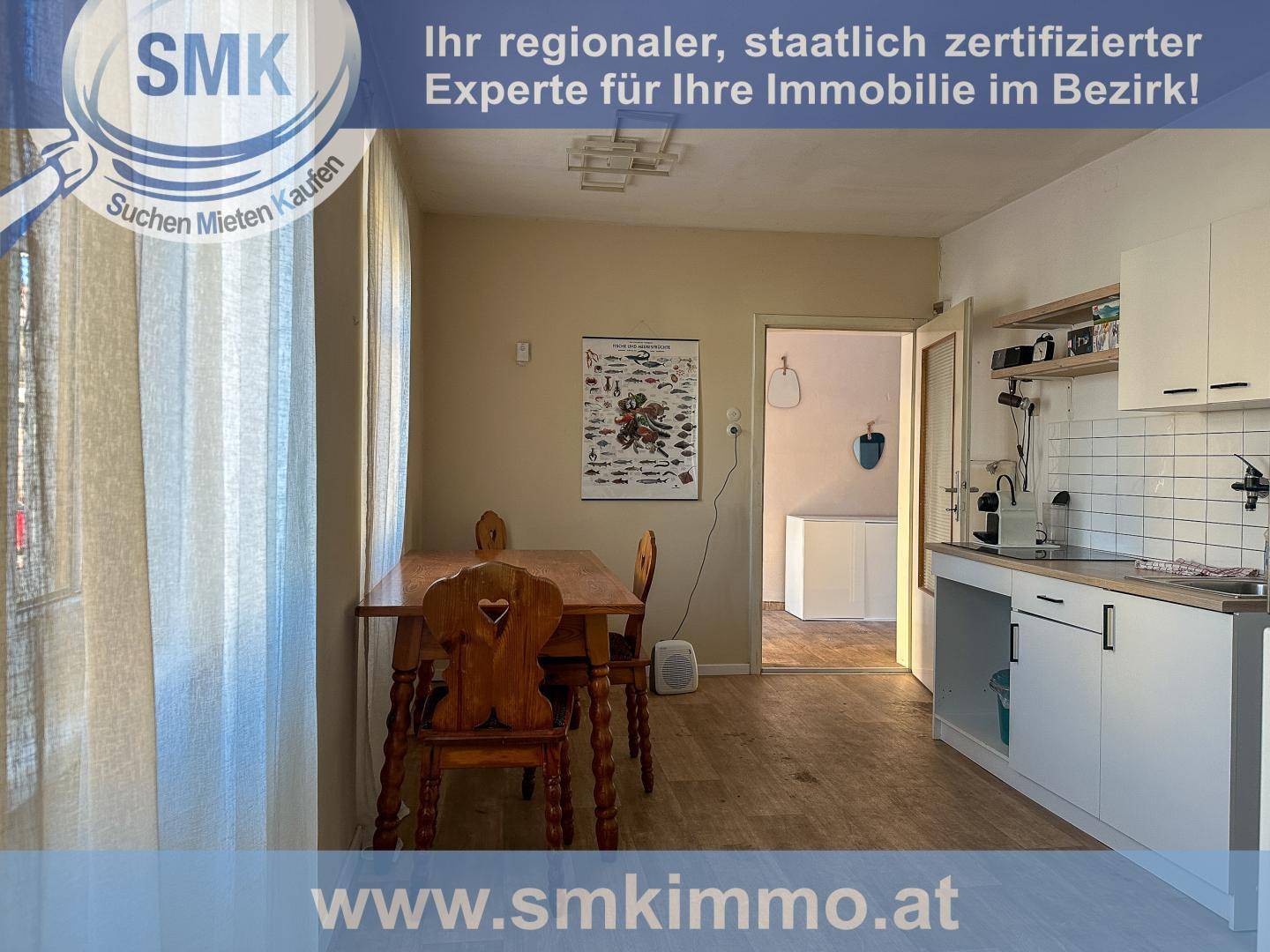 Funktionale Küche mit Essbereich, weißen Schränken und Blick in den Nebenraum.