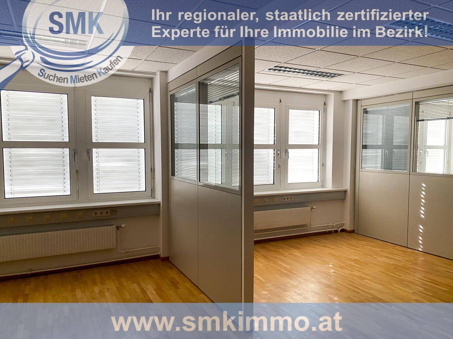 Offener Bürobereich mit modularen Trennwänden, großen Fenstern und Holzfußboden, ideal für flexible Arbeitsplätze.