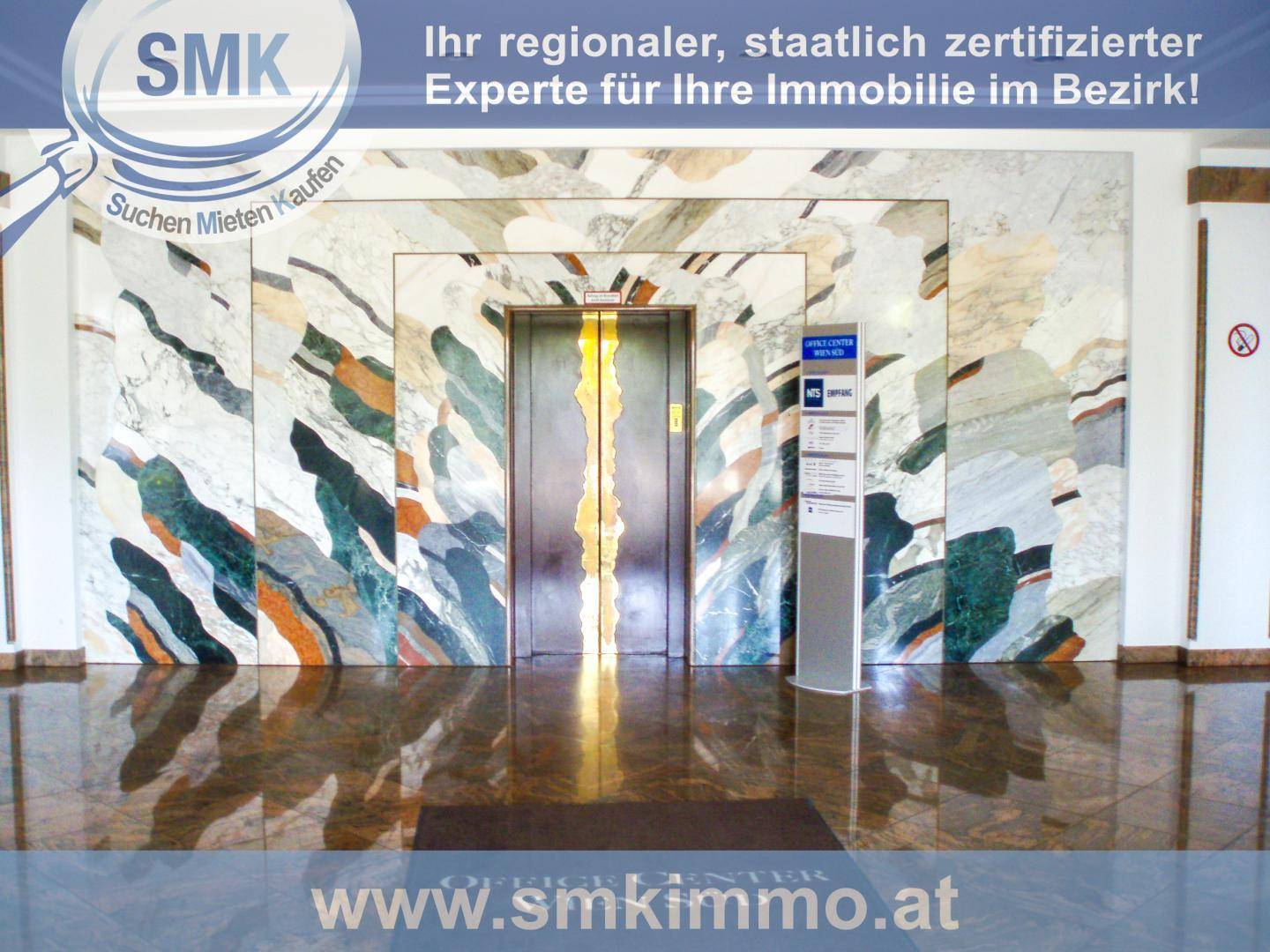 Elegante Lobby mit einem Aufzug, umgeben von kunstvoll gemusterten Marmorwänden und glänzendem Boden.