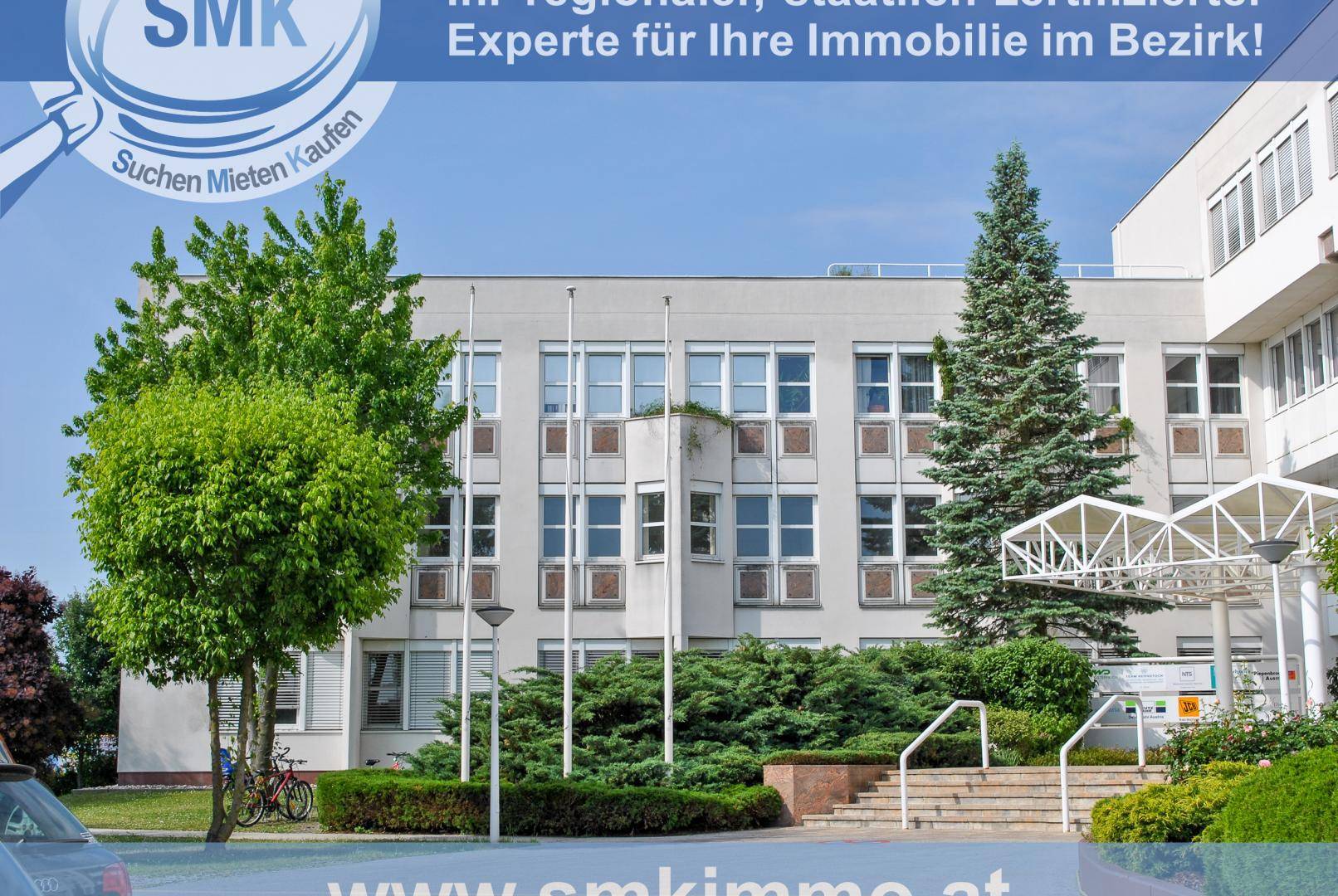 Außenansicht eines modernen Bürogebäudes mit großen Fenstern und gepflegter Grünanlage.