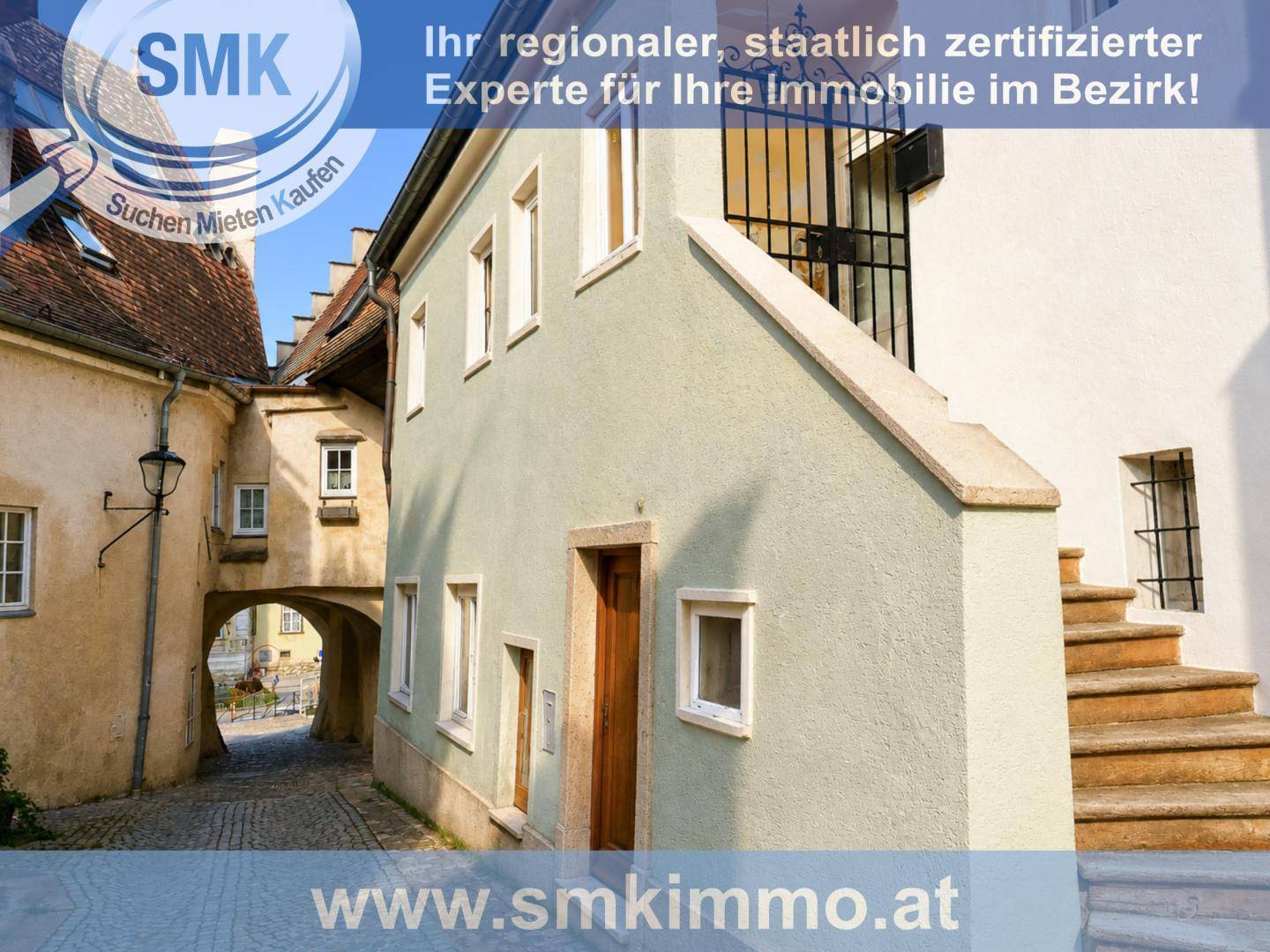 Historische Gasse mit Kopfsteinpflaster und alten Gebäuden unter blauem Himmel.