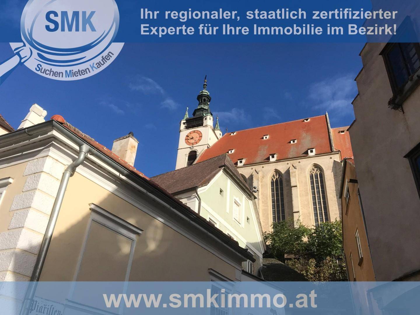 Historische Kirche mit Uhrturm und umliegenden alten Gebäuden unter blauem Himmel.