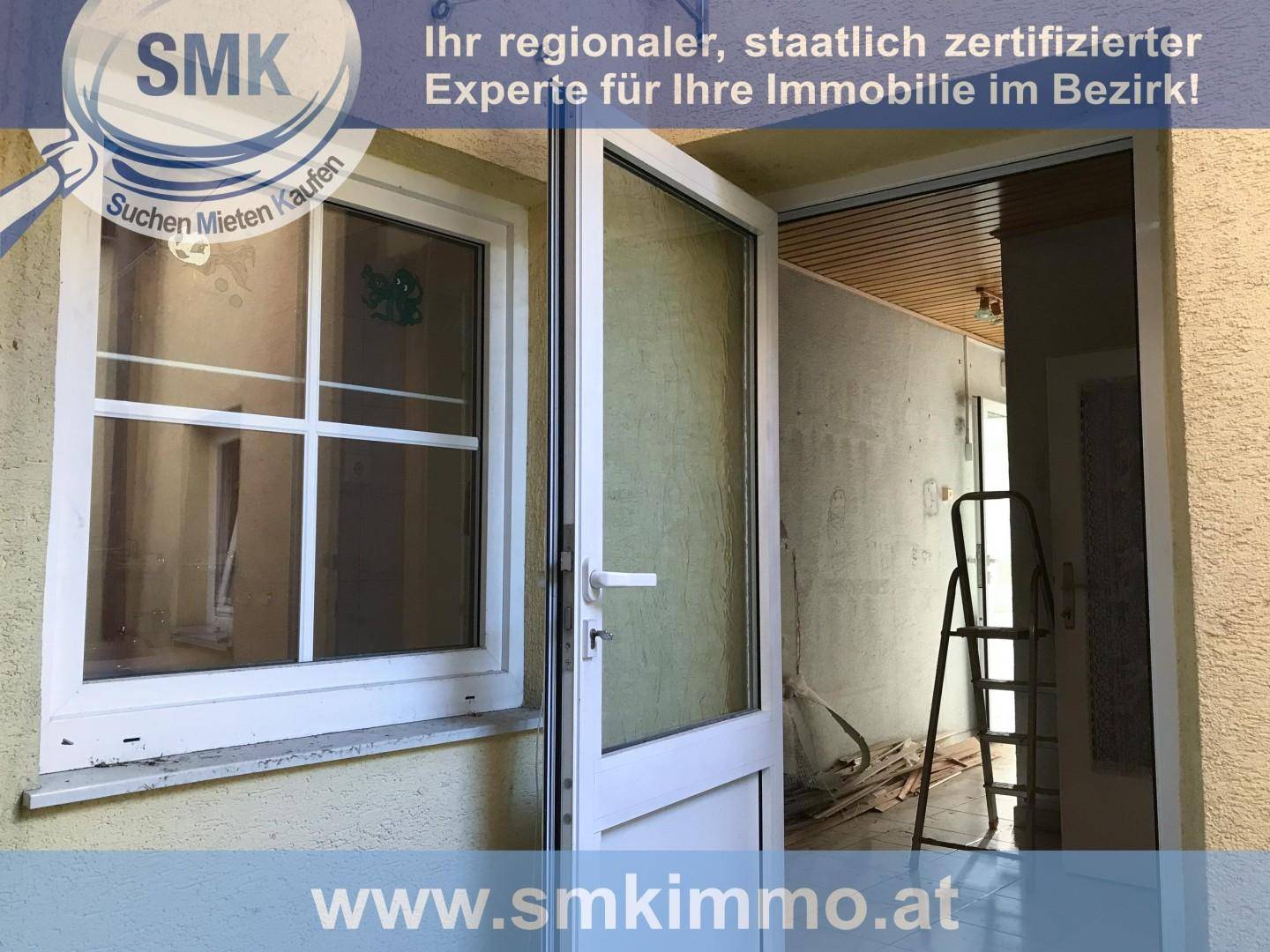 Hauseingang mit weißer Tür und Fenster, dahinter ein Raum im Renovierungszustand.