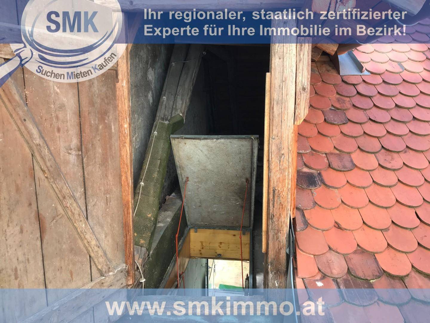 Dachboden mit sichtbaren Holzbalken und einer Dachluke, unter einem Ziegeldach.