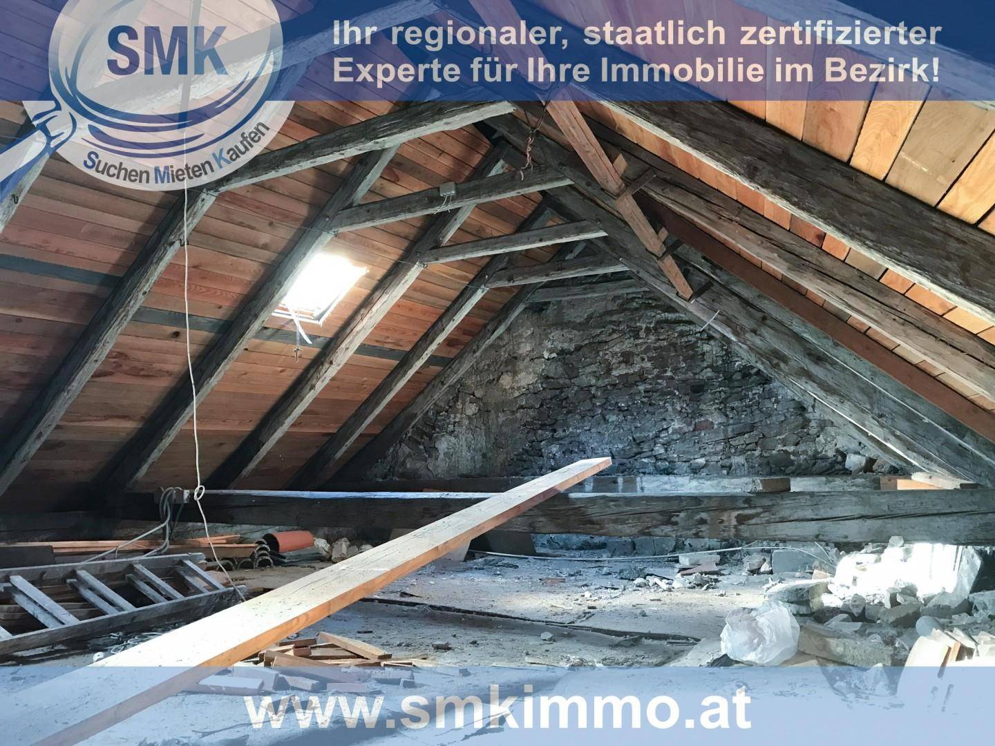 Geräumiger Dachboden im Rohzustand mit Holzbalken, Dachfenster und Baumaterialien.