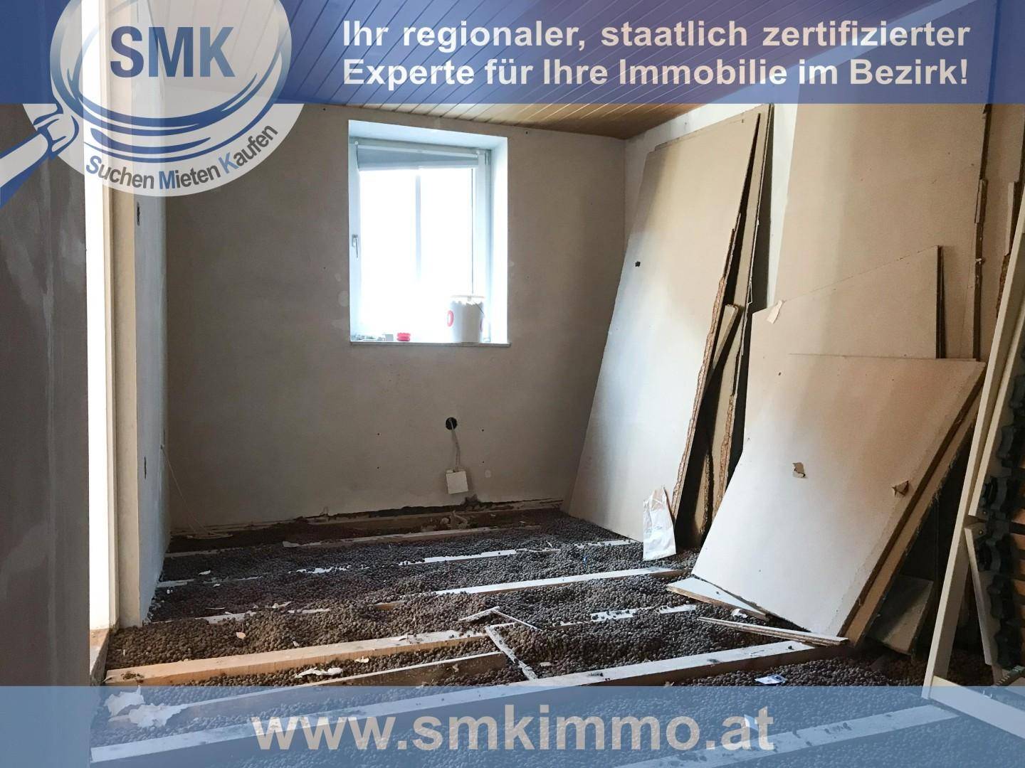 Renovierungsbedürftiger Raum mit offenem Bodenaufbau, Holzbalken und einem Fenster.