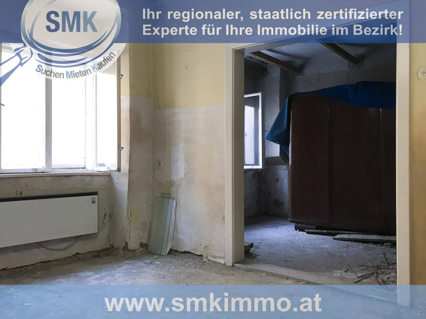 Unfertiger Raum mit kahlen Wänden, Heizkörper und Blick in einen weiteren Renovierungsbereich.