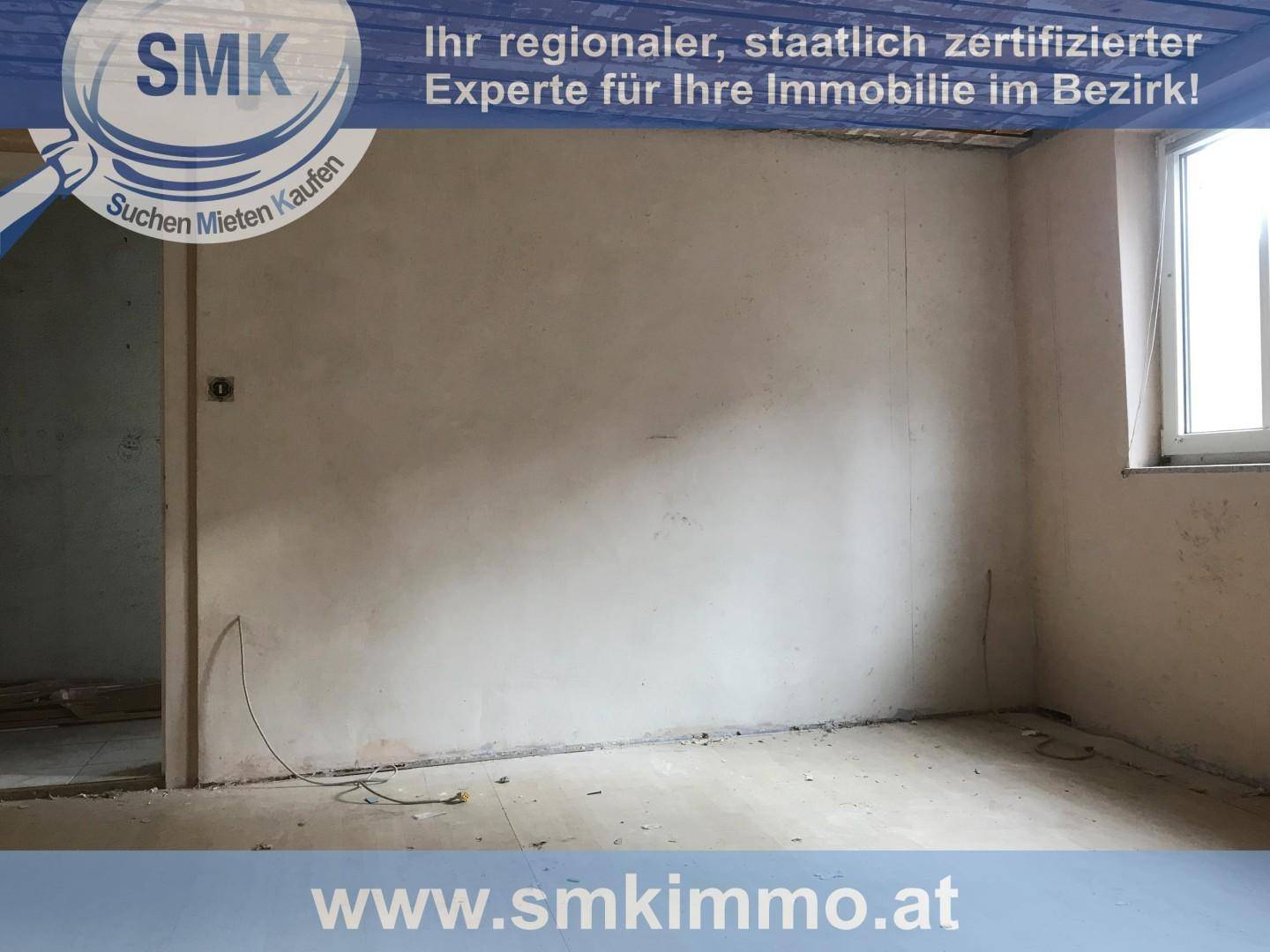 Leerer Raum im Rohbau mit unverputzten Wänden und einem Fenster, bereit zur Renovierung.
