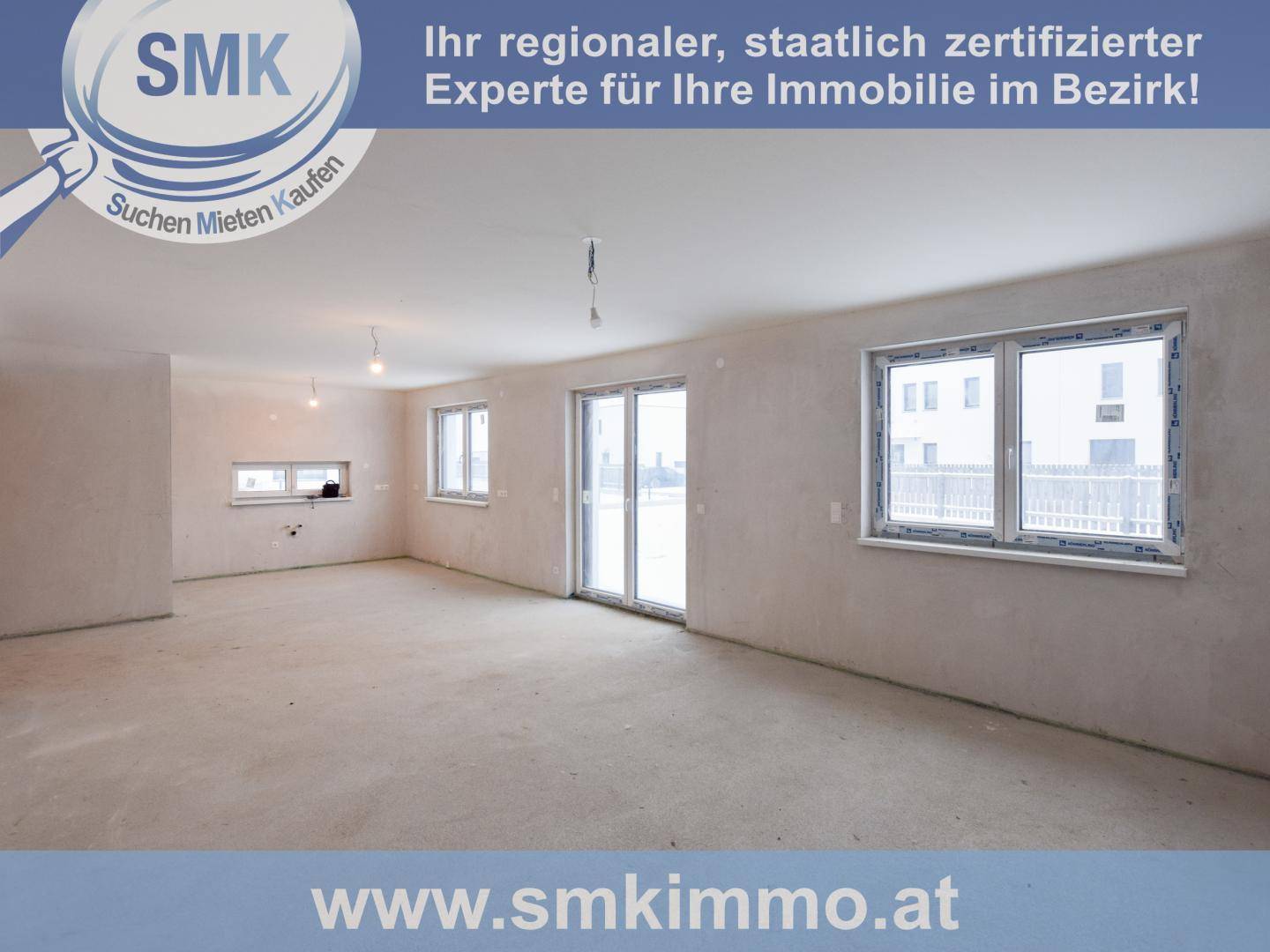Heller Rohbau-Innenraum mit mehreren großen Fenstern und Zugang zum Außenbereich.