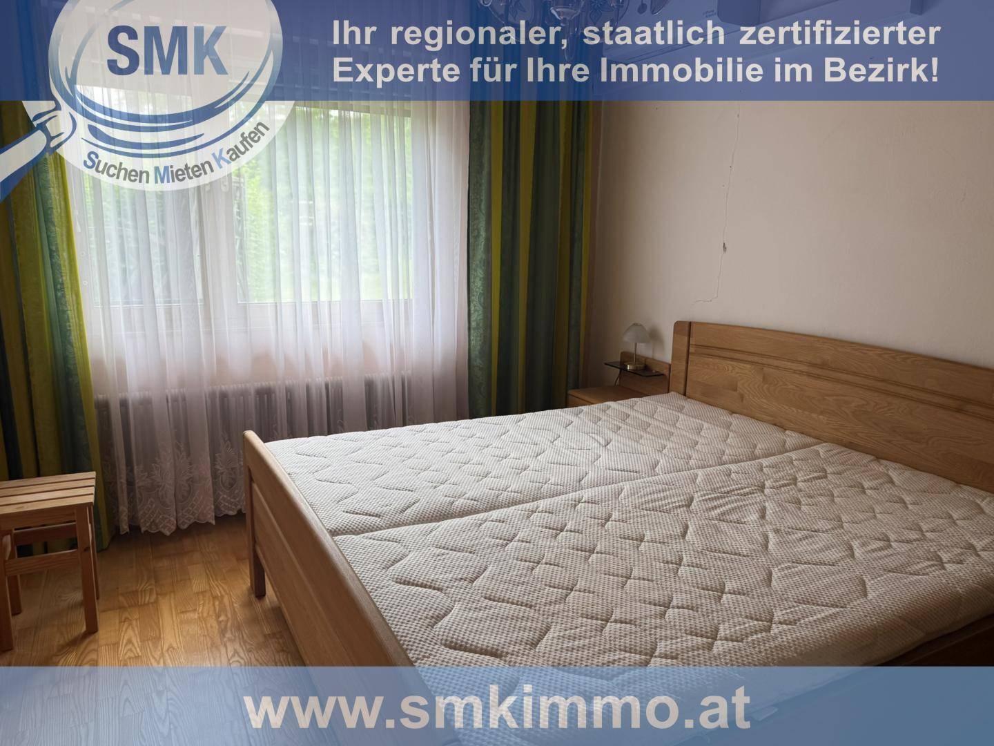 Schlafzimmer mit hellem Holzbett und Parkettboden, gut beleuchtet durch ein Fenster.
