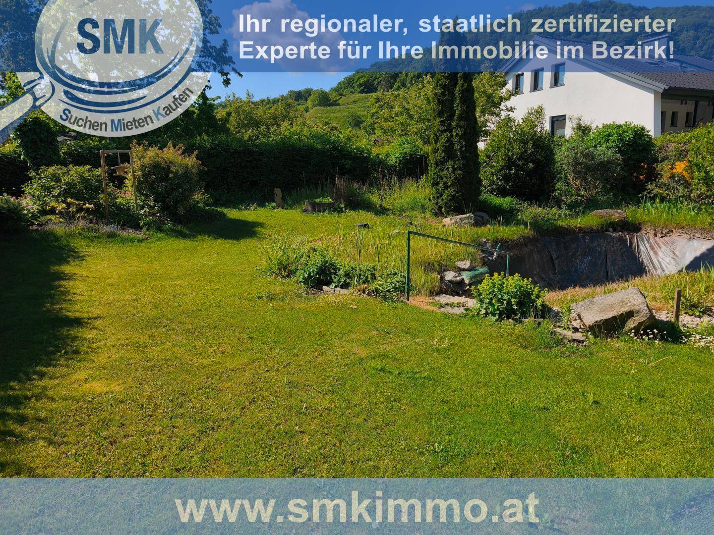 Weitläufige Rasenfläche im Garten mit Blick auf das Haus und die grüne Umgebung.
