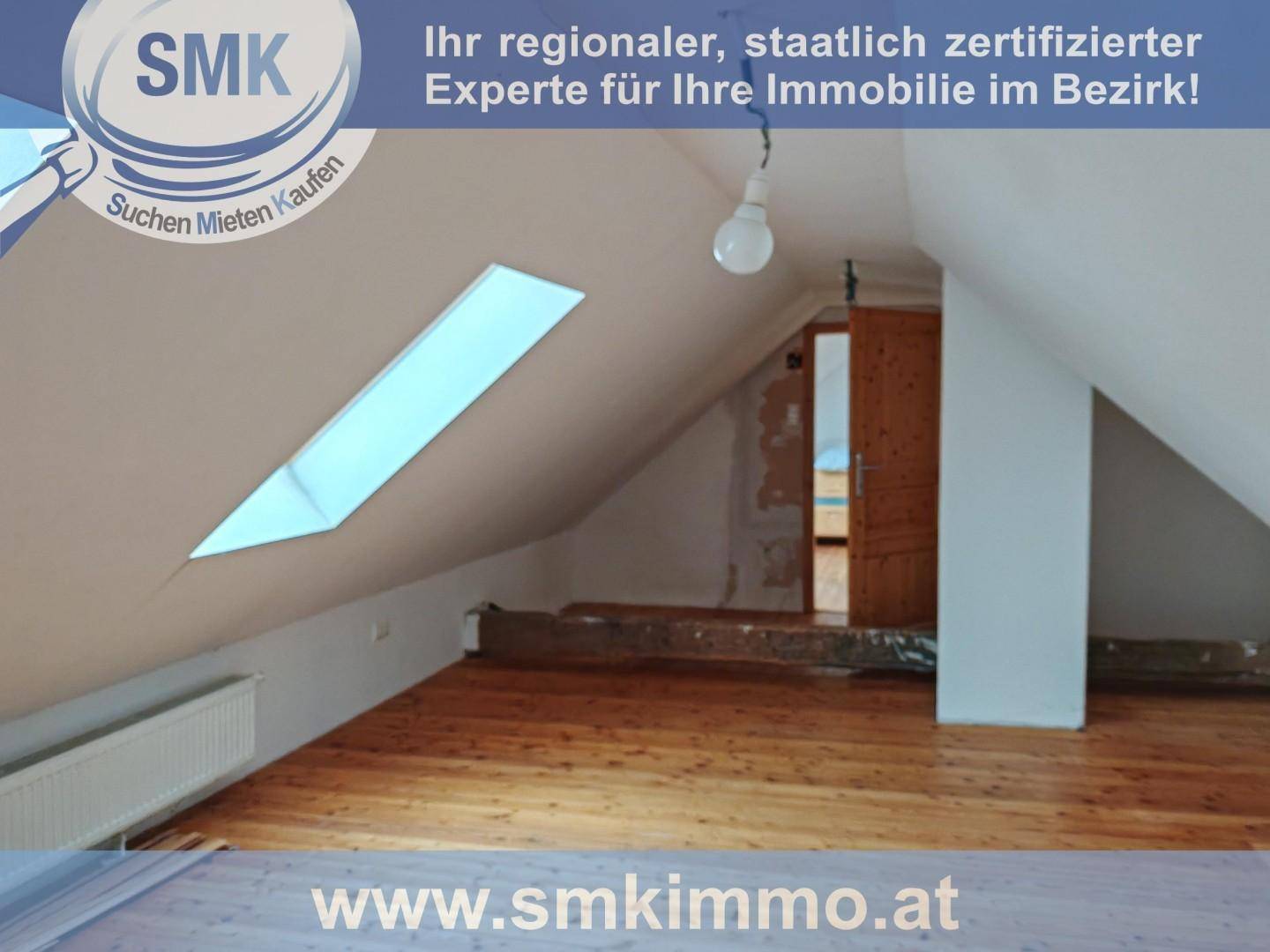 Dachgeschossraum mit Holzboden, sichtbarem Balken und Dachfenster, das den Raum erhellt.