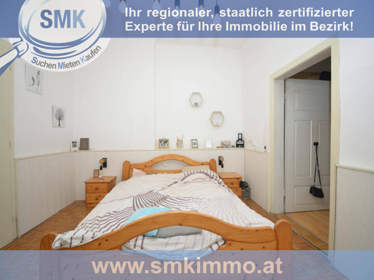 Schlafzimmer mit Doppelbett aus Holz, Nachttischen und weiß getäfelten Wänden.