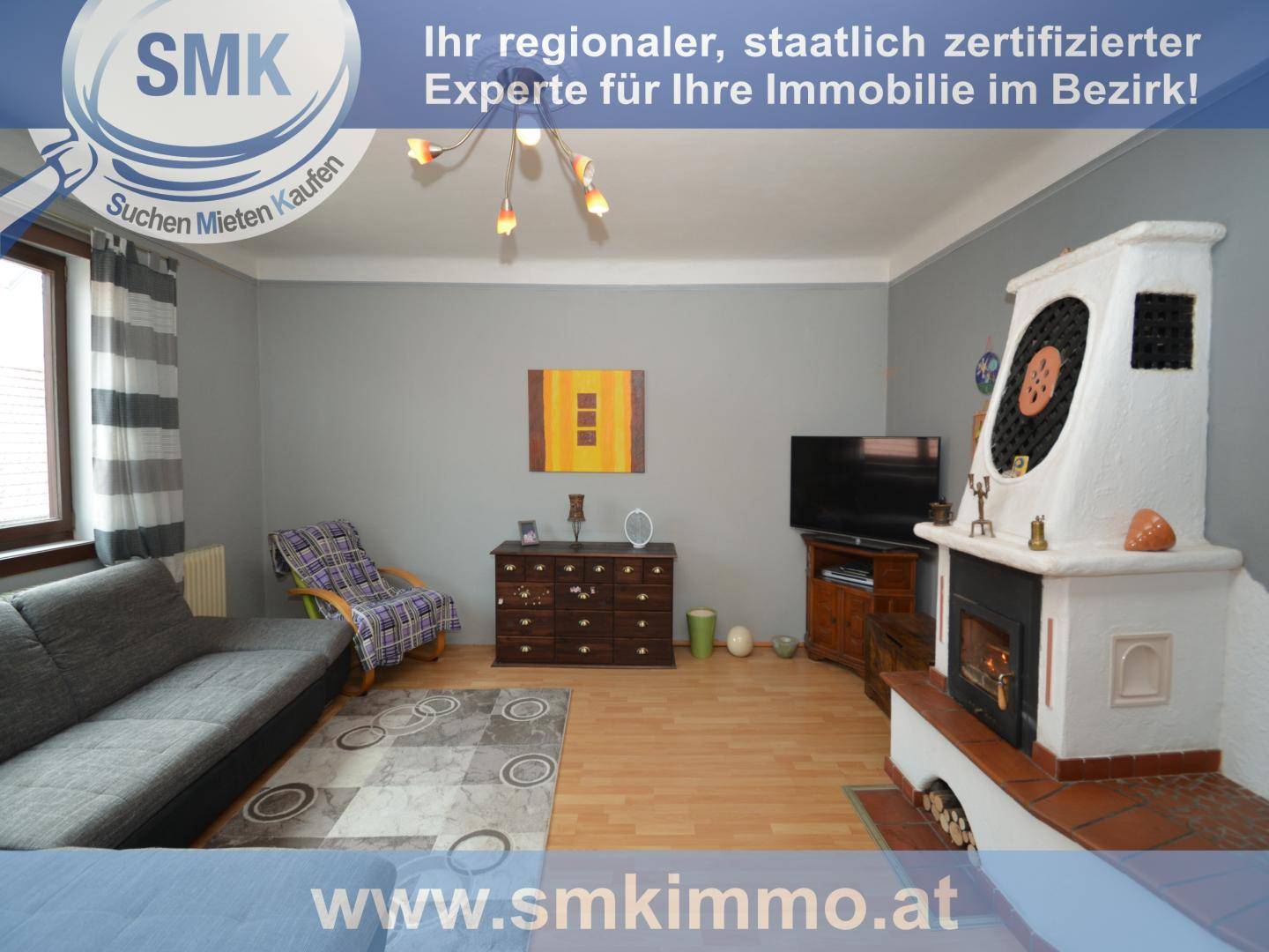 Wohnzimmer mit Kachelofen, Sofa und Holzboden, ideal für gemütliche Abende.