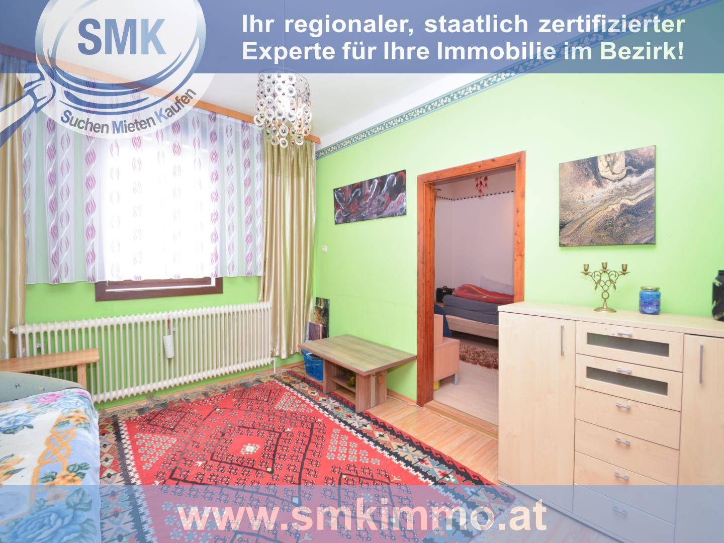 Helles Schlafzimmer mit grün gestrichenen Wänden, Teppich und Zugang zu einem weiteren Raum.
