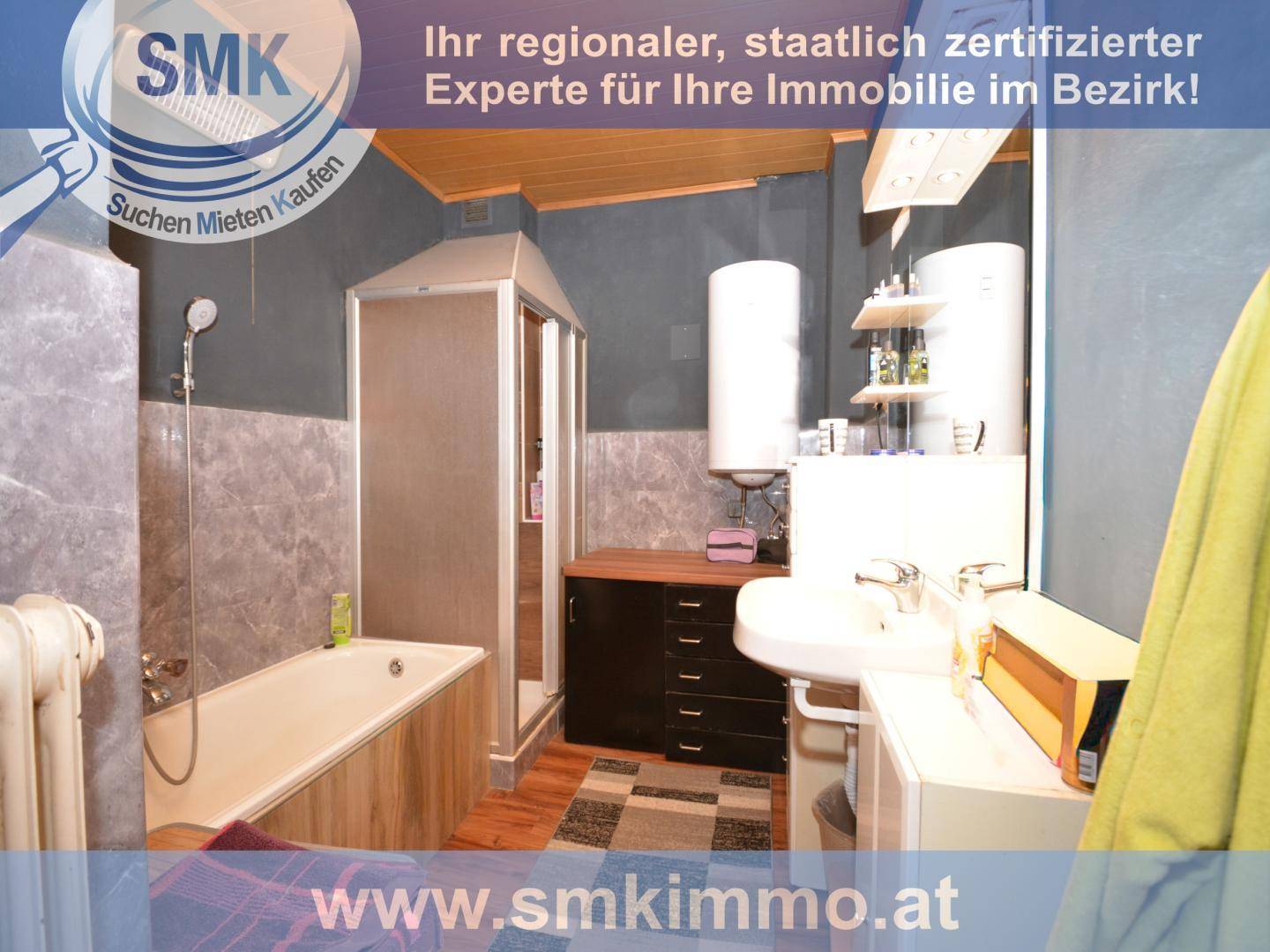 Badezimmer mit Badewanne, Dusche und Waschbecken, ausgestattet mit Fliesen und Holzdecke.