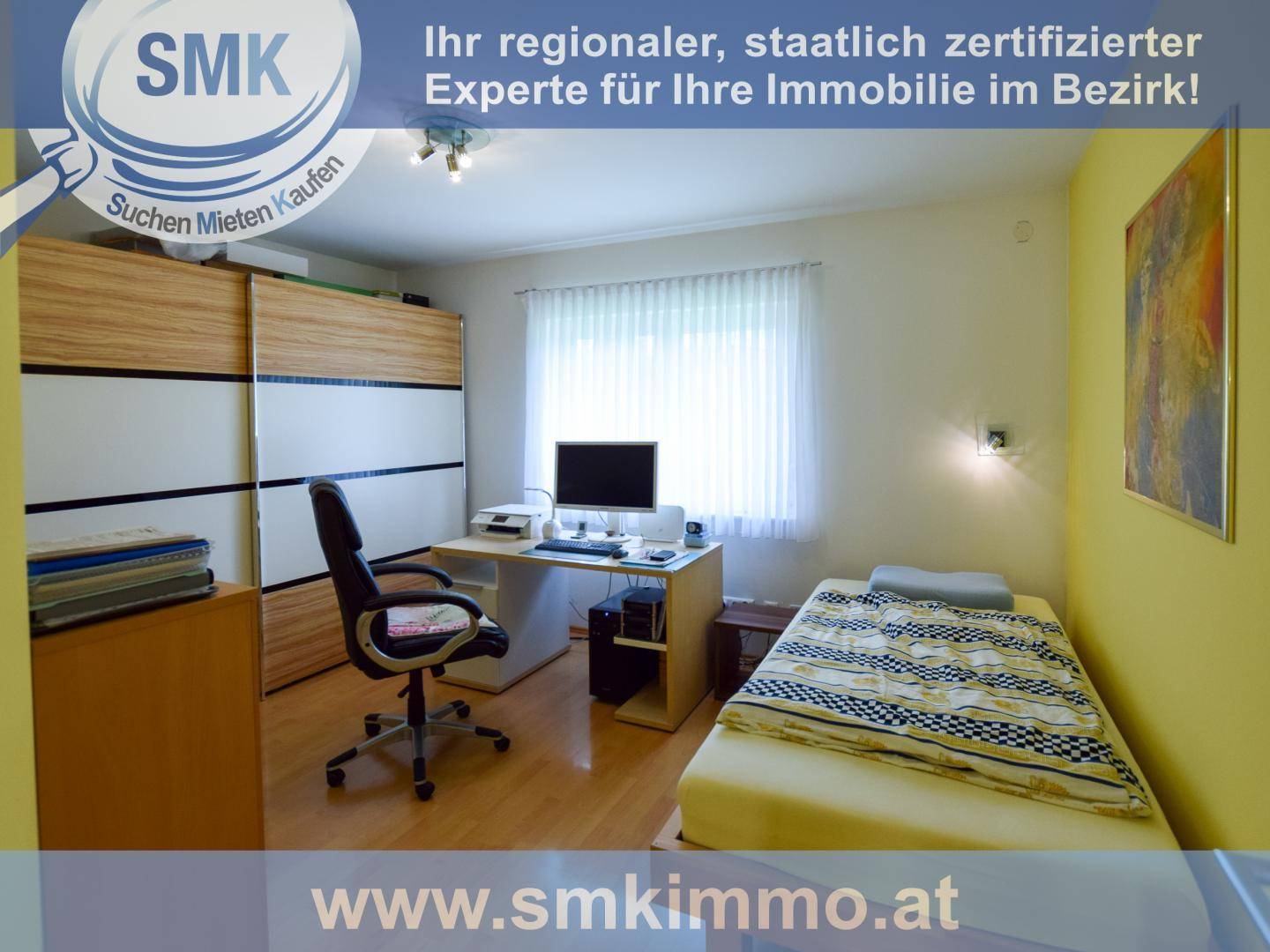 Helles Schlafzimmer mit Einzelbett, Schreibtisch und großem Kleiderschrank.