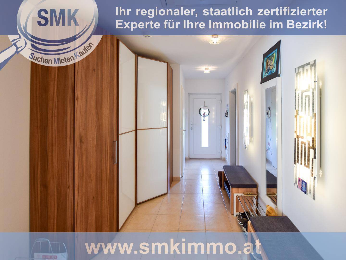 Heller Eingangsbereich mit Fliesenboden, Garderobenschrank und dekorativen Wandleuchten.