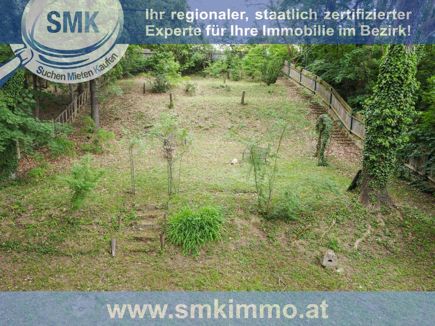 Weitläufiges Gartengrundstück mit Treppen und viel Grün, umgeben von Bäumen.