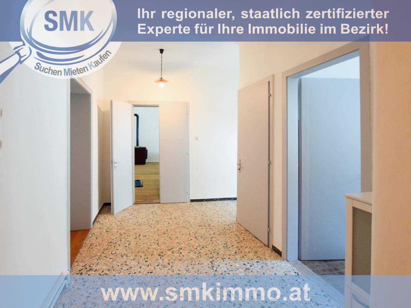 Langer Flur mit Terrazzoboden und mehreren Türen, die zu verschiedenen Räumen führen.
