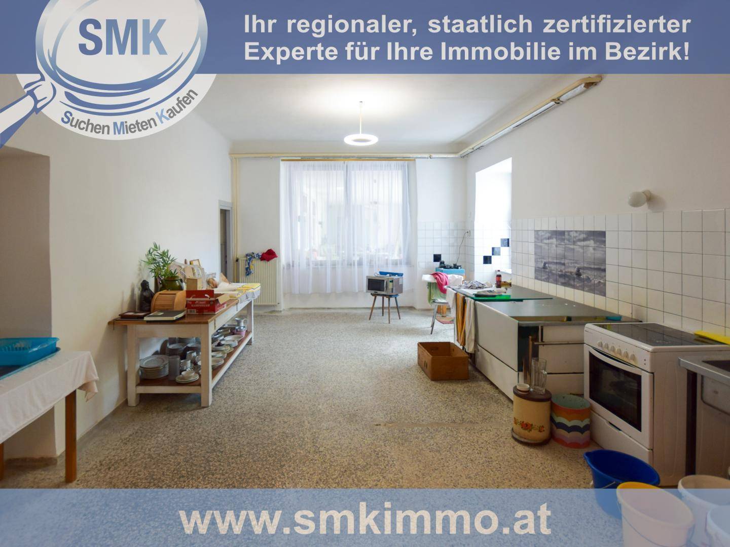 Einfache Küche mit alten Geräten und Fliesen an der Wand, bereit für eine Renovierung.