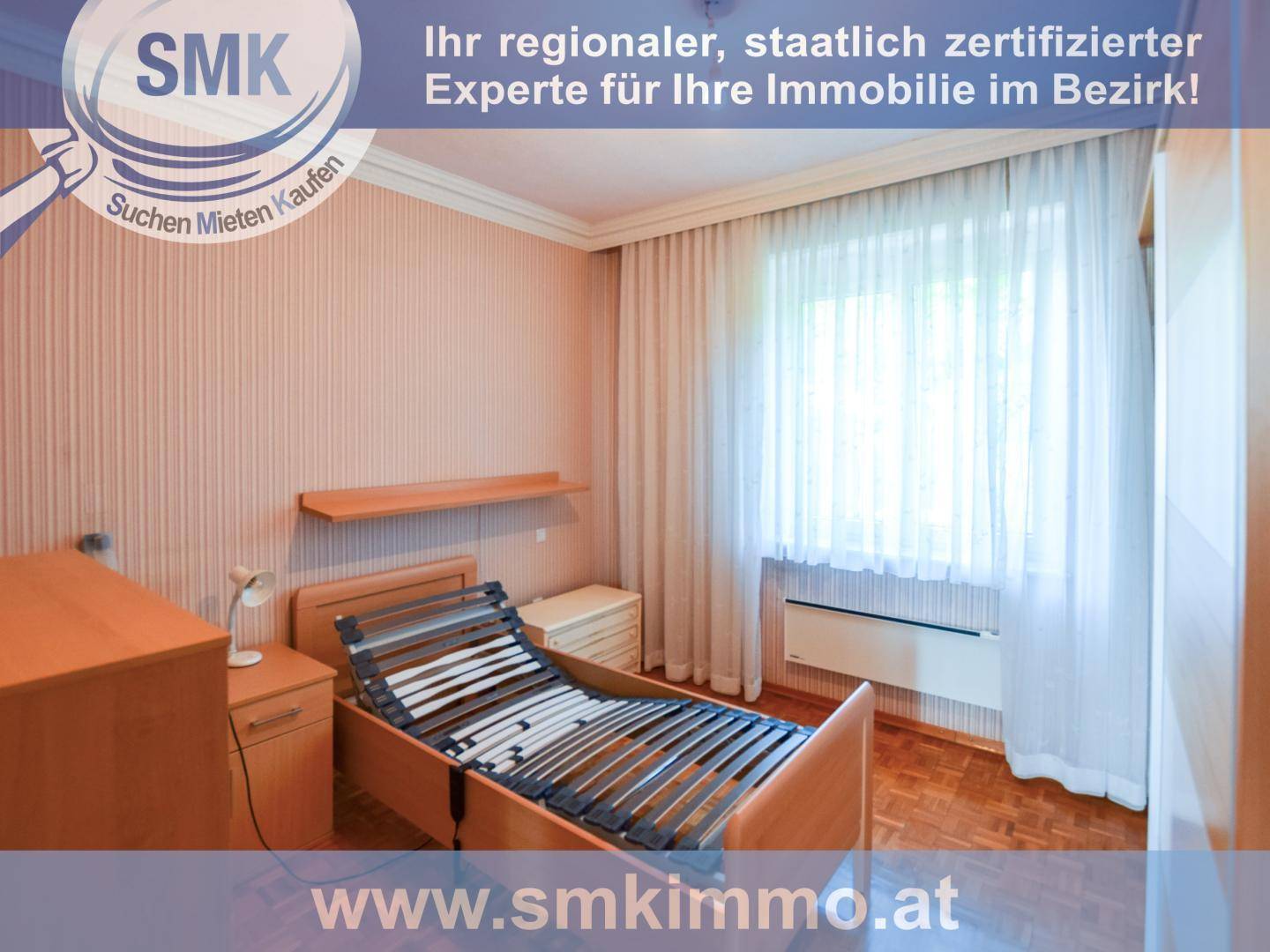 Schlafzimmer mit Holzbettrahmen, Nachttischen und einem Fenster mit Vorhängen.