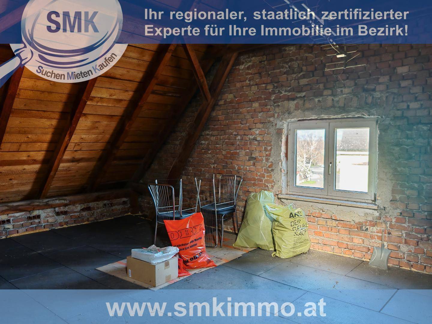 Dachbodenraum mit freiliegenden Ziegelwänden und Holzdachstuhl, bereit für Ausbau.
