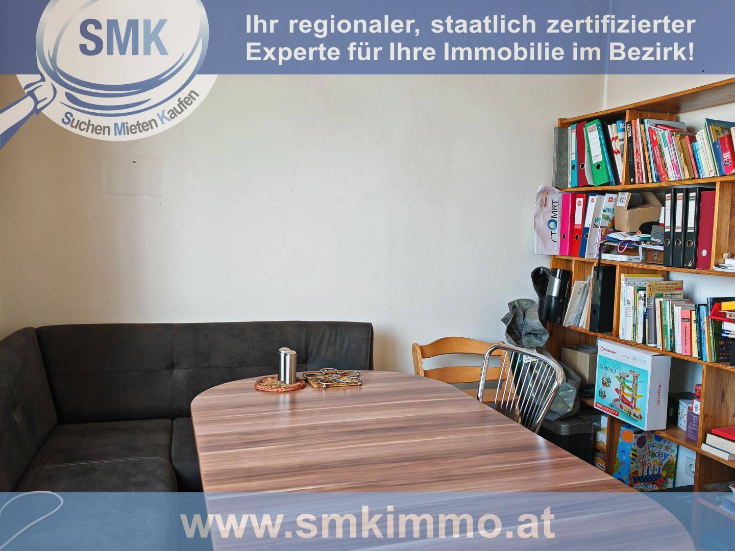 Essbereich oder Arbeitszimmer mit Eckbank, Holztisch und einem Bücherregal.