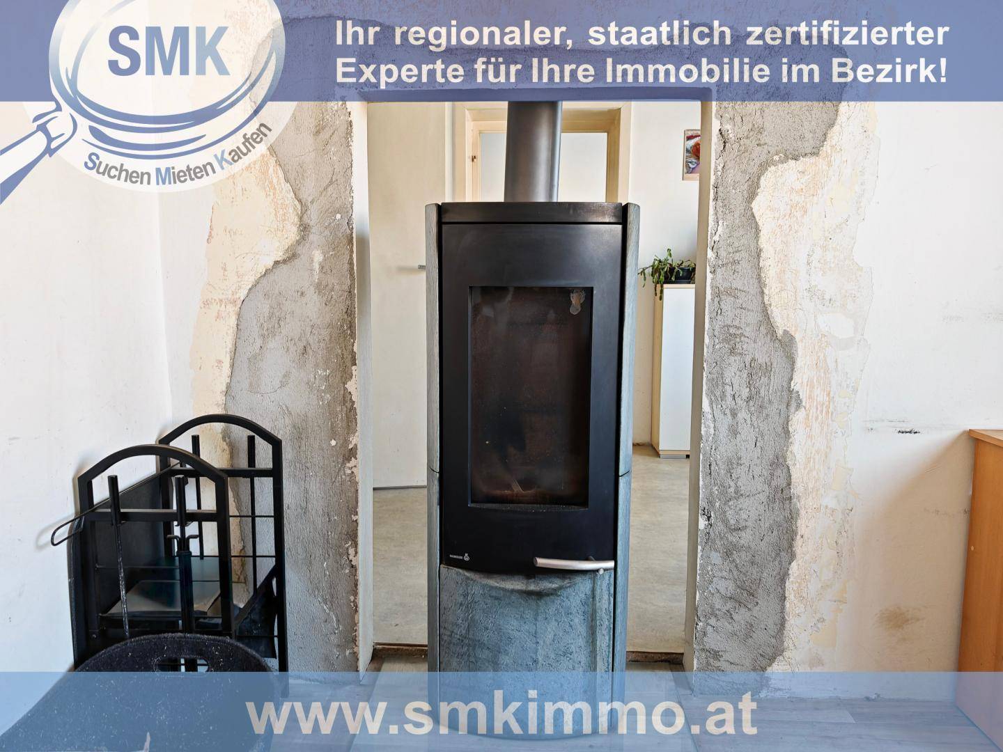 Holzofen in einem Raum, der sich in einem unfertigen oder renovierungsbedürftigen Zustand befindet.