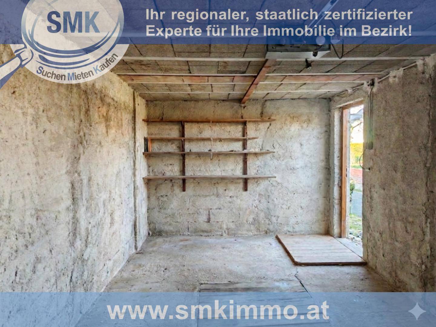 Lagerraum mit rauen Betonwänden, Betonboden und einfachen Holzregalen für Stauraum.