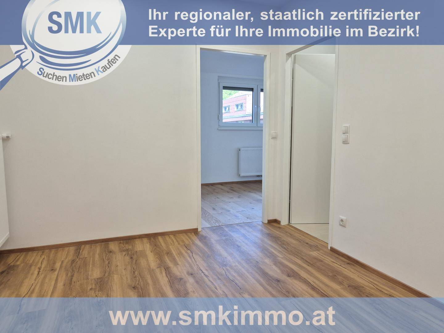 Leerer Raum mit Holzboden und weiß gestrichenen Wänden, der zu einem weiteren Zimmer führt.