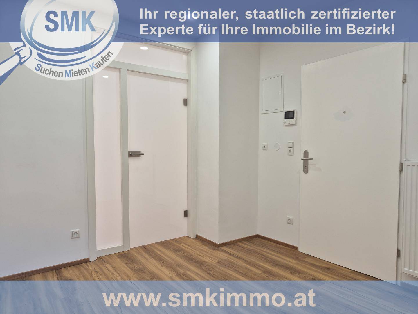 Heller Flur mit Holzboden und mehreren weißen Türen, darunter eine mit Glaseinsatz.