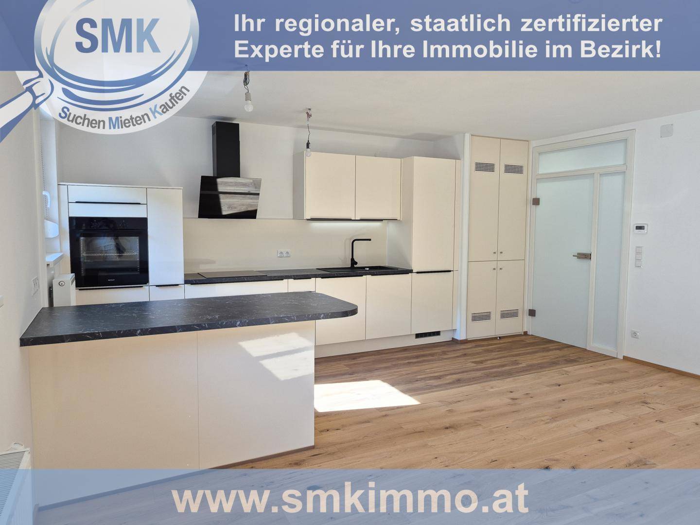 Helle Einbauküche mit weißen Fronten, schwarzer Arbeitsplatte und integrierten Geräten.
