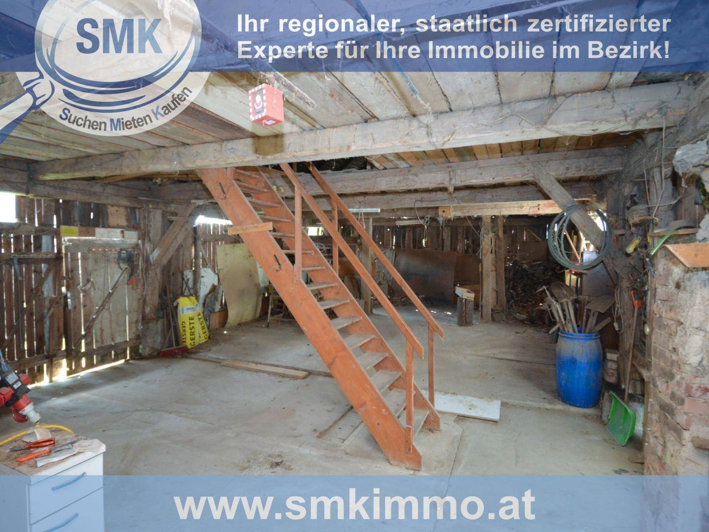 Rustikaler Wirtschaftsraum mit sichtbaren Holzbalken und einer Holztreppe, ideal als Lagerfläche.