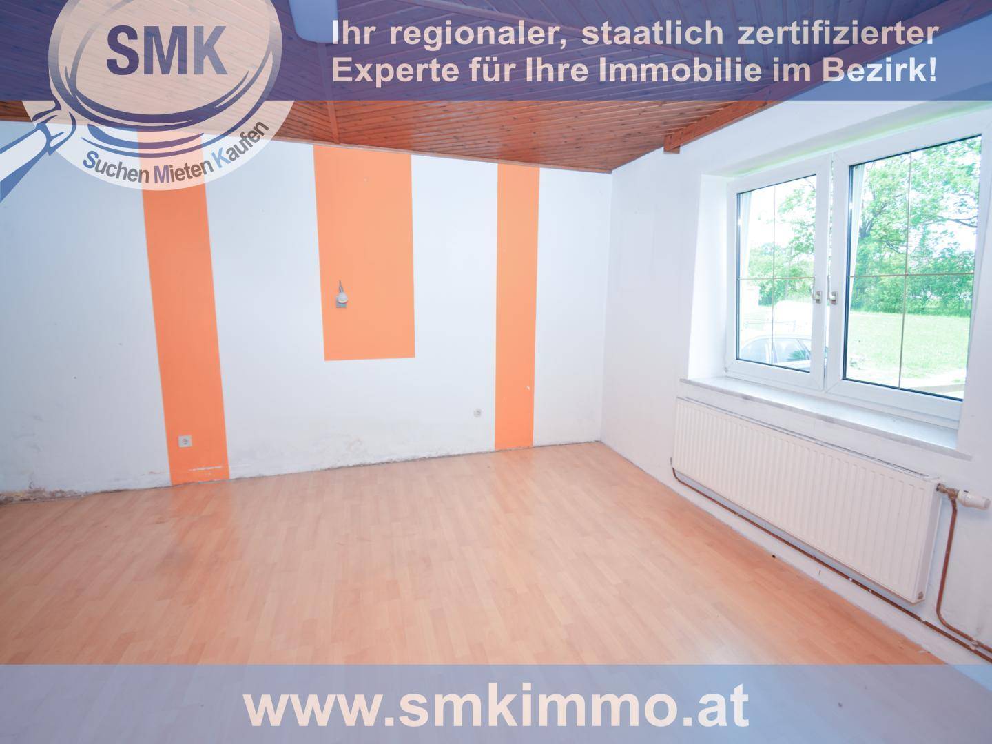 Heller Raum mit hellem Holzboden, orange-weiß gestreiften Wänden und einem großen Fenster.