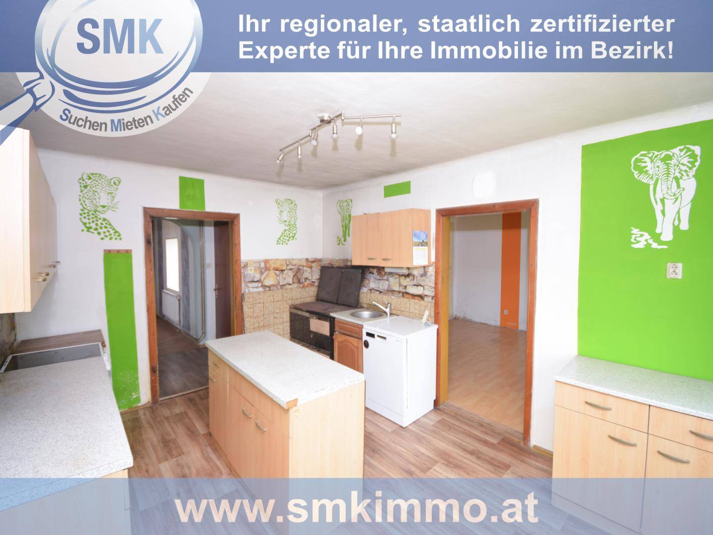 Küche mit Holzschränken, Kücheninsel und farbenfrohen Wanddekorationen, die eine lebendige Atmosphäre schaffen.
