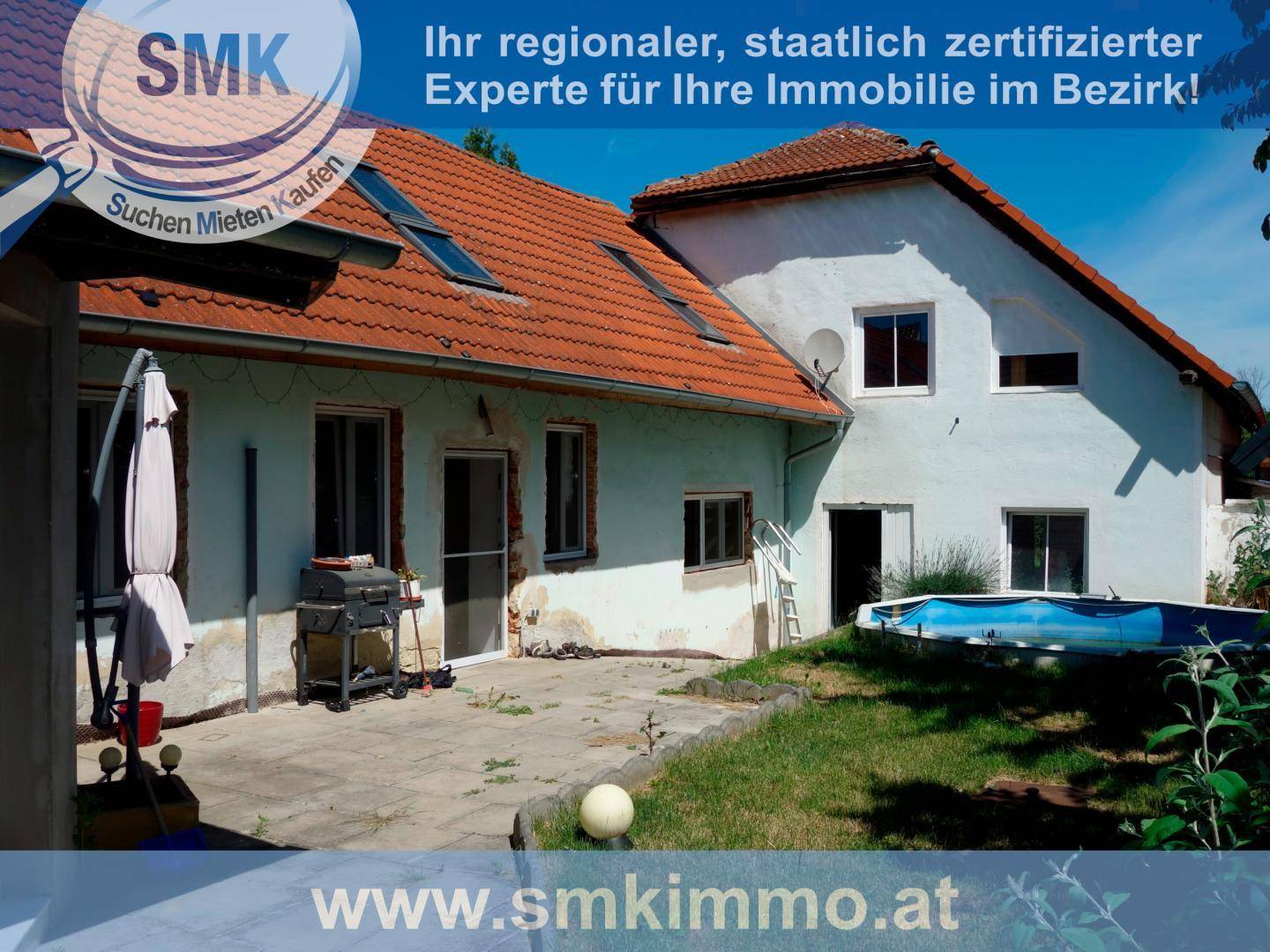 Hausrückseite mit gepflasterter Terrasse, Grillbereich und kleinem Aufstellpool im Garten.