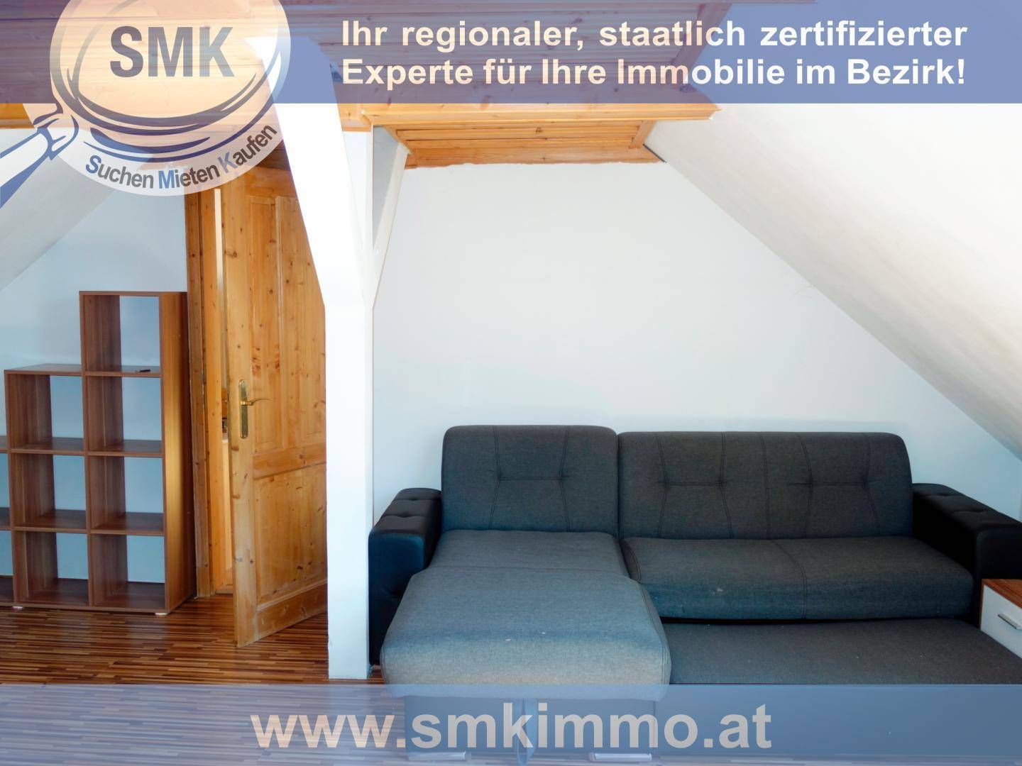 Gemütliches Dachgeschosszimmer mit Sofa, Holzfußboden und Dachschräge, ideal als Rückzugsort.