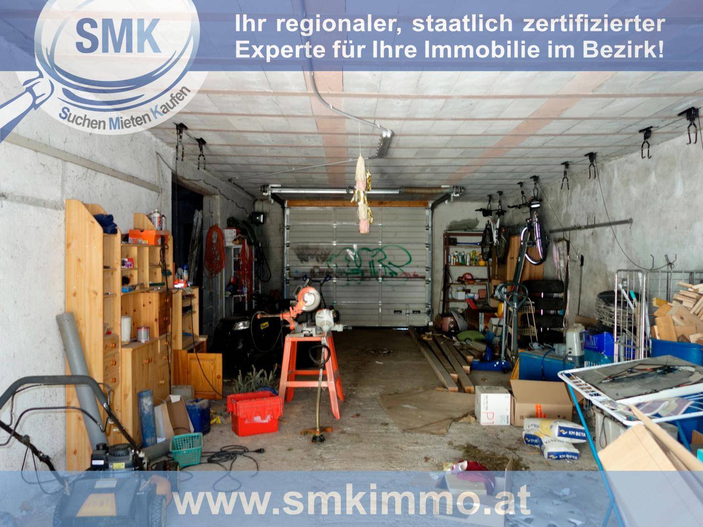 Geräumige Garage mit Rolltor, Werkzeugen und Lagerregalen, ideal für Hobby und Abstellzwecke.
